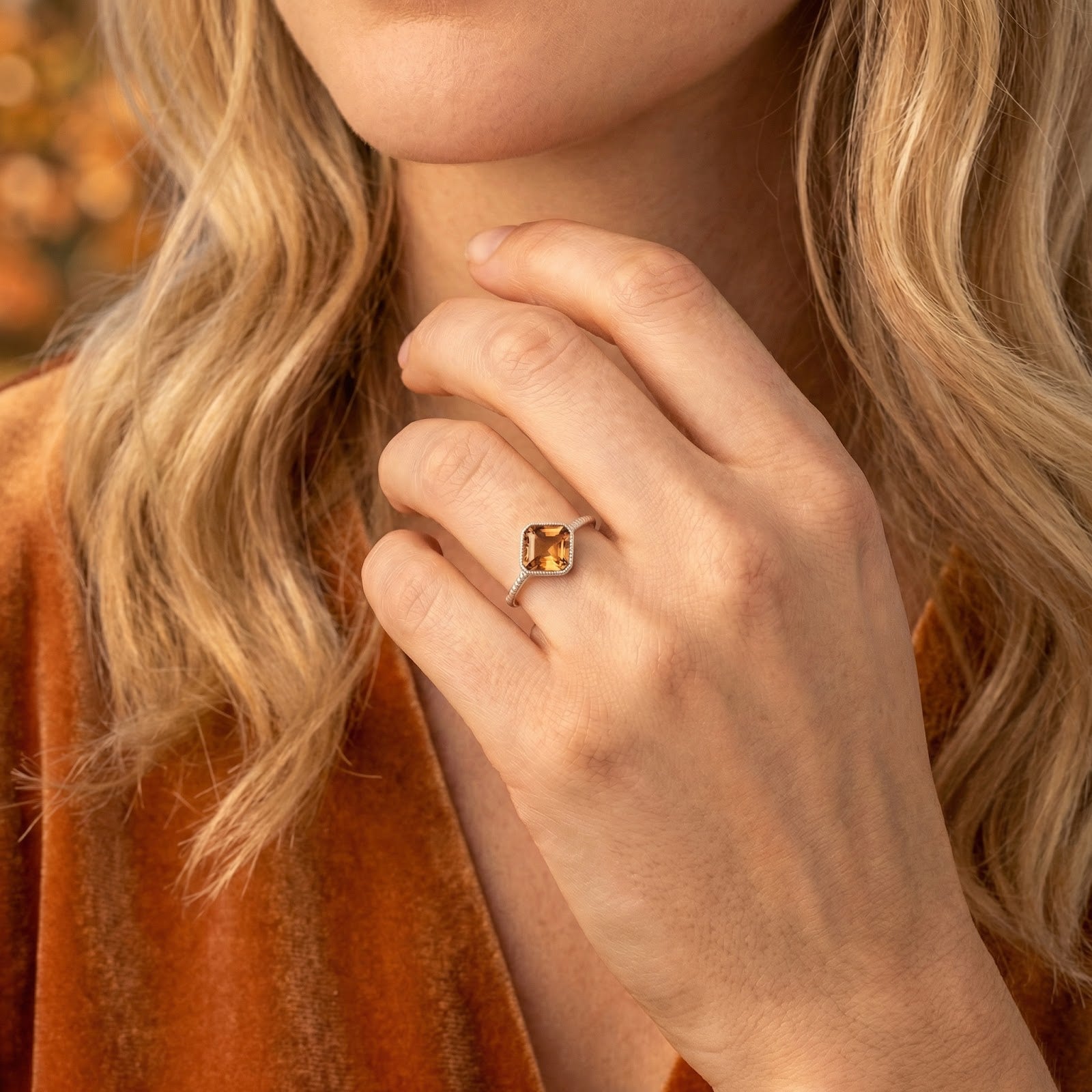 Model wearing the cushion-cut honey gold simulated topaz silver ring with an autumn-themed velvet dress.