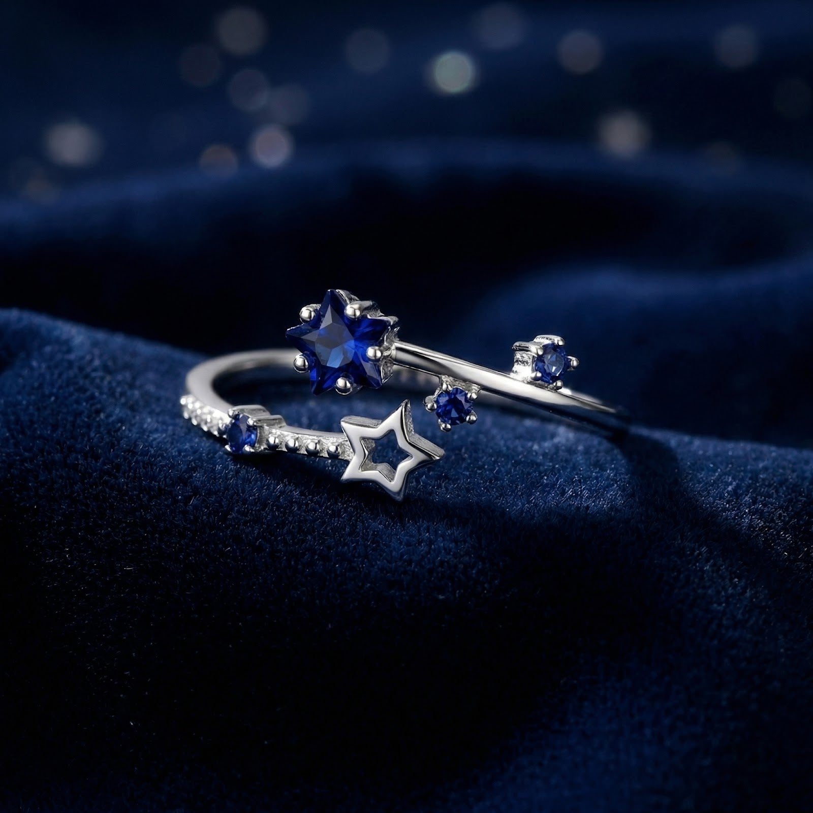 Macro side view of the star-cut blue simulated sapphire and silver bypass setting on dark blue velvet.
