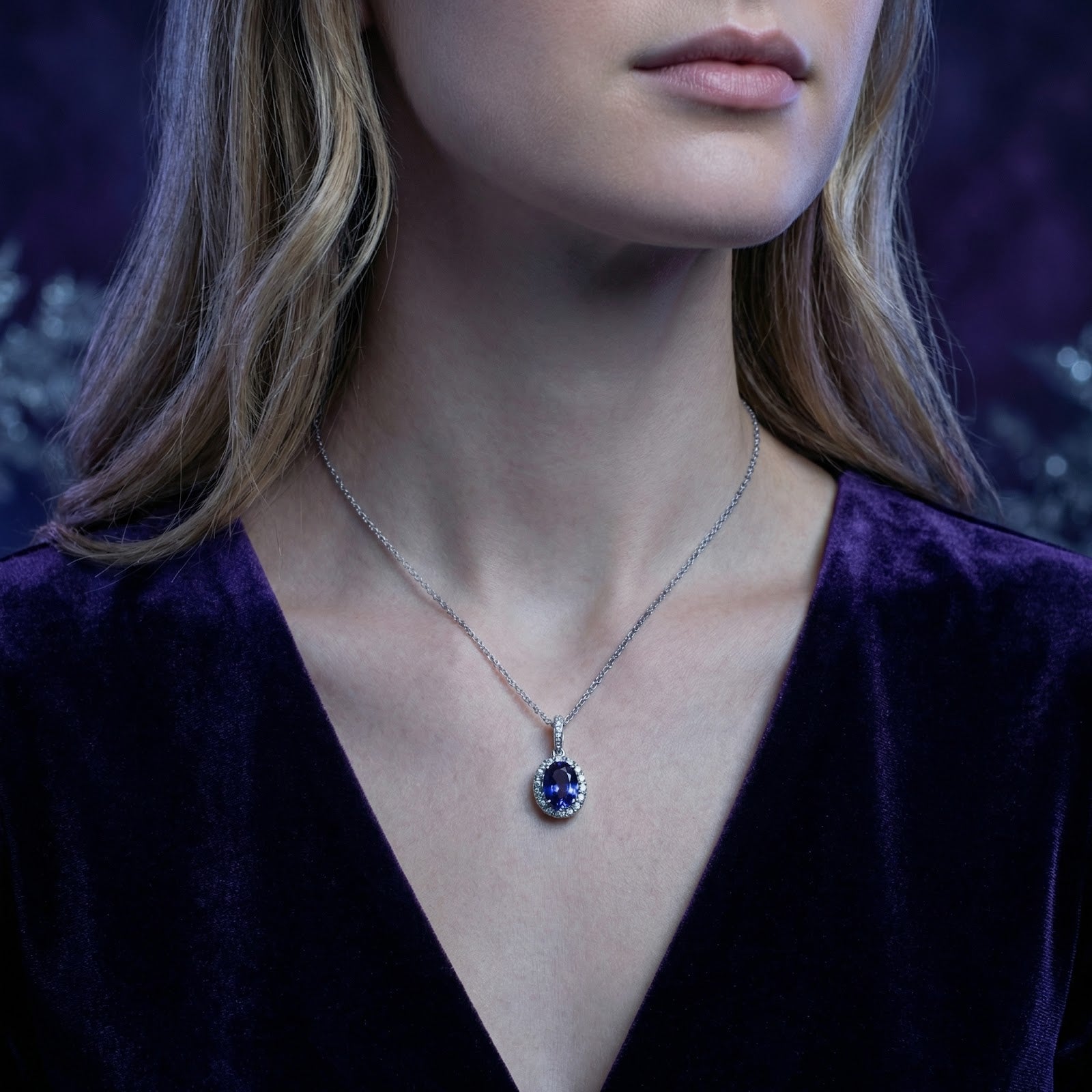 Woman wearing the Azurienne oval simulated tanzanite halo necklace in sterling silver on a delicate chain.