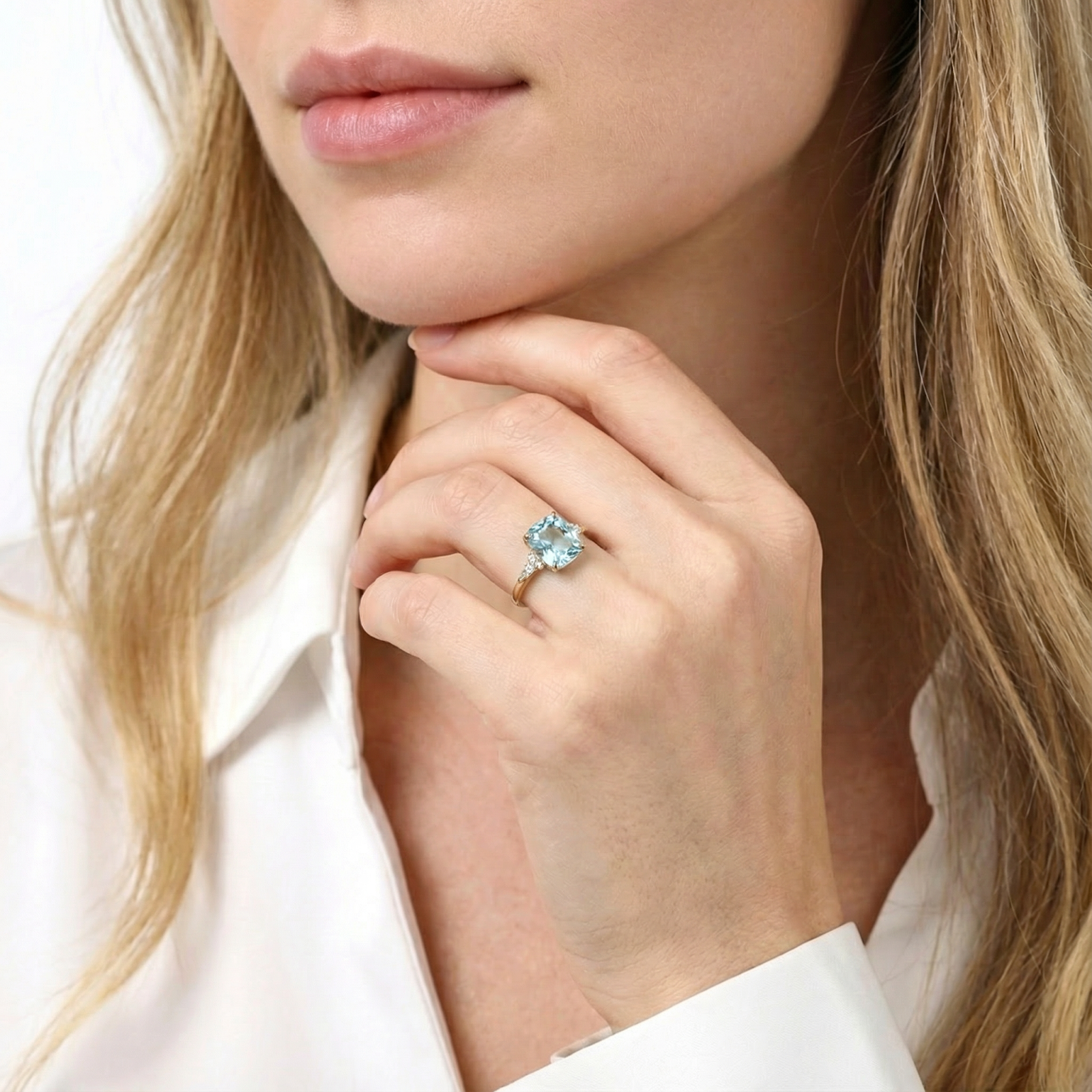 Model wearing the Zephyra cushion cut simulated aquamarine ring in 18K gold vermeil on her finger.