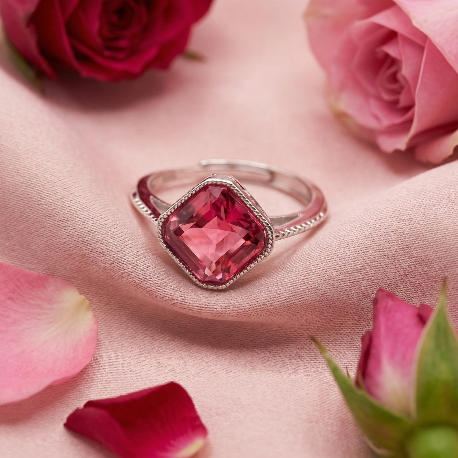 Arisette cushion-cut pink tourmaline ring in sterling silver on pink silk with rose petals.