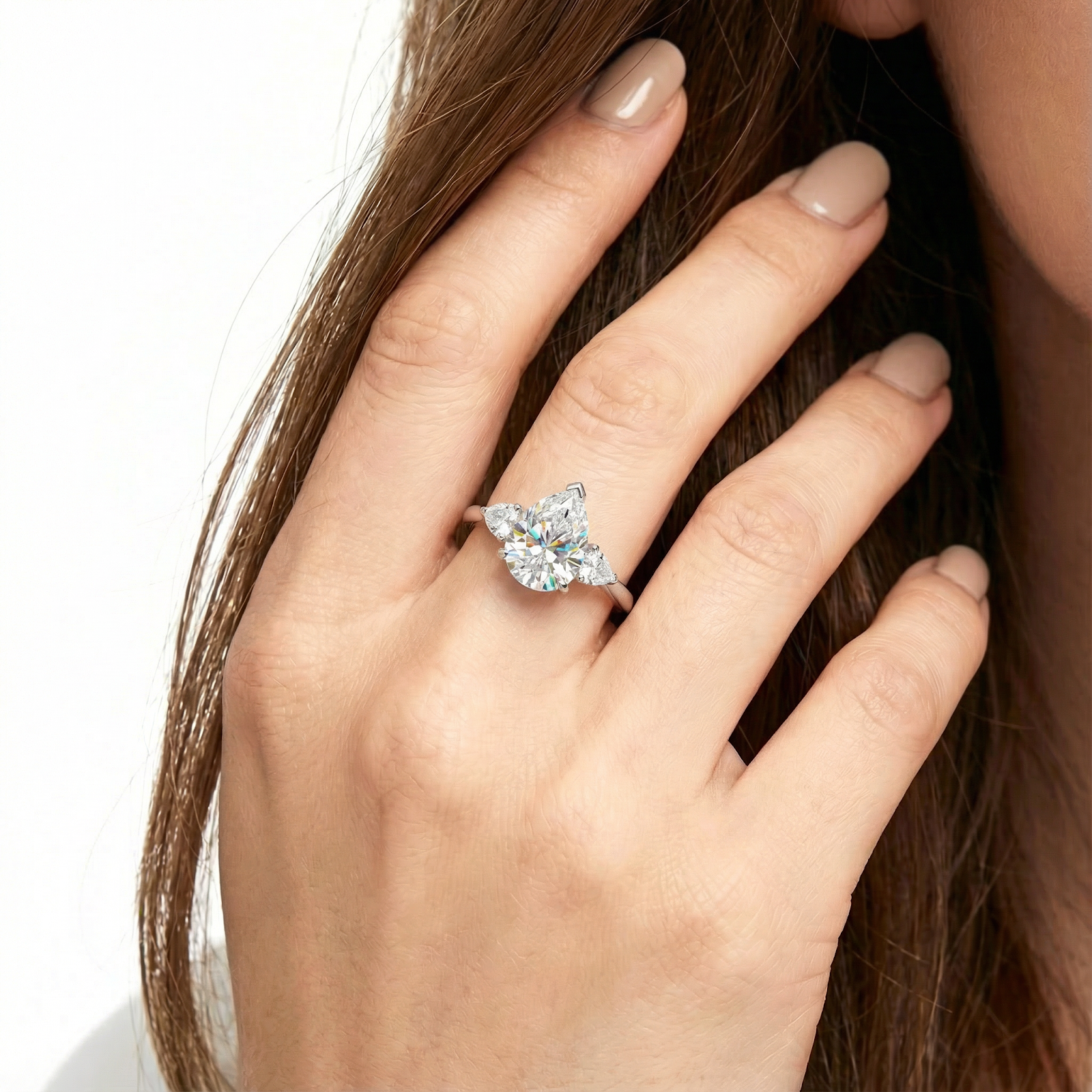 Pear cut simulated diamond trio ring in S925 sterling silver worn on a woman's hand.