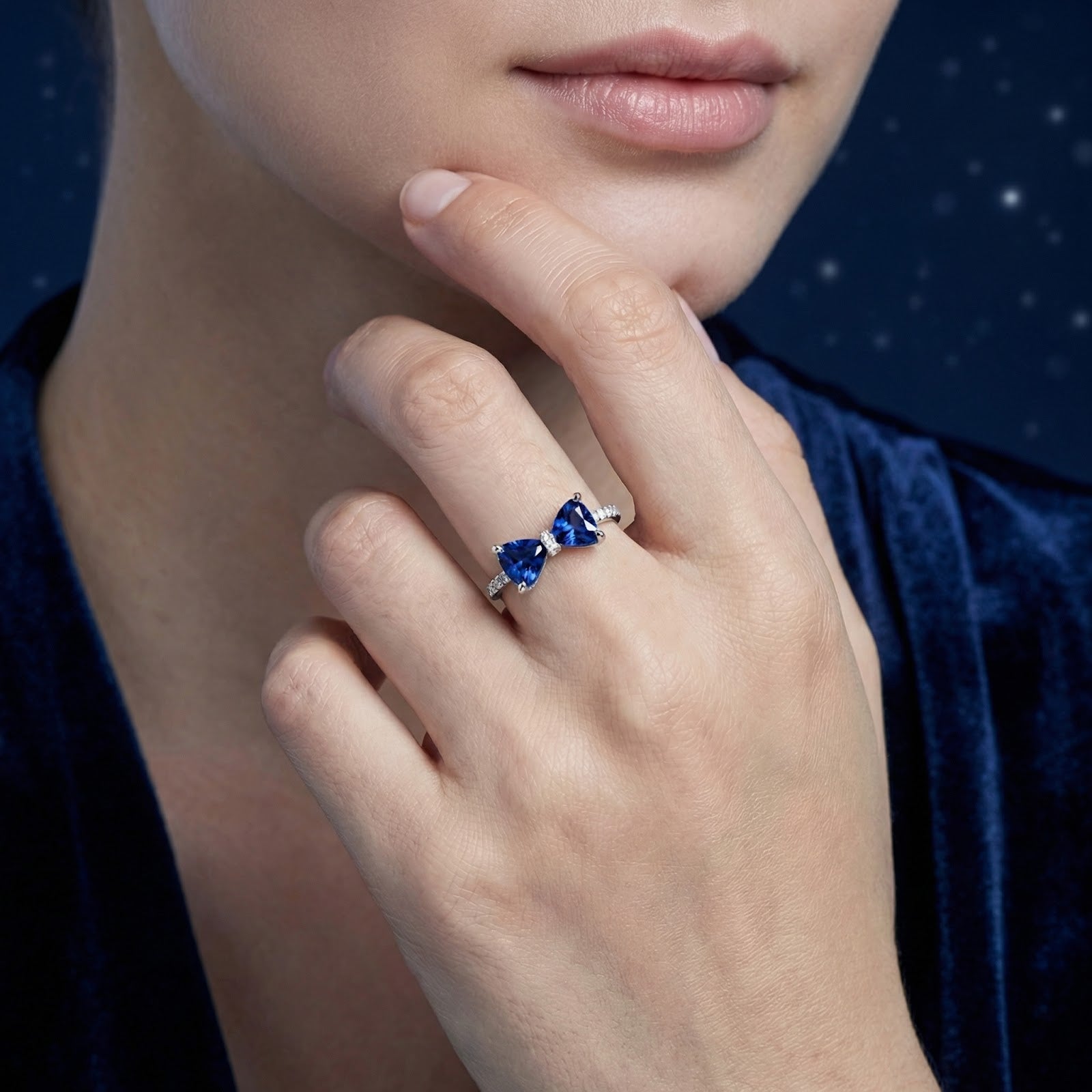Model wearing the S925 sterling silver Marcelle bow ring with blue trillion-cut simulated sapphires on her finger.