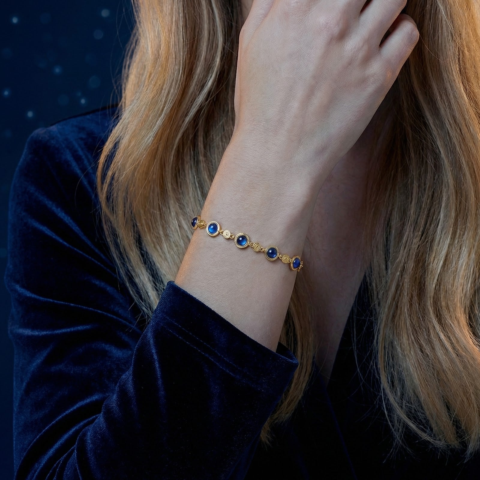 18K gold vermeil station bracelet with blue simulated sapphires styled on a model's wrist.