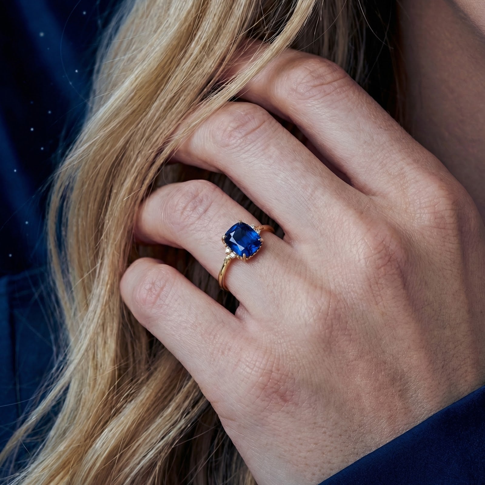 Woman wearing the Arisara cushion-cut simulated sapphire ring in 18K gold vermeil on her ring finger.