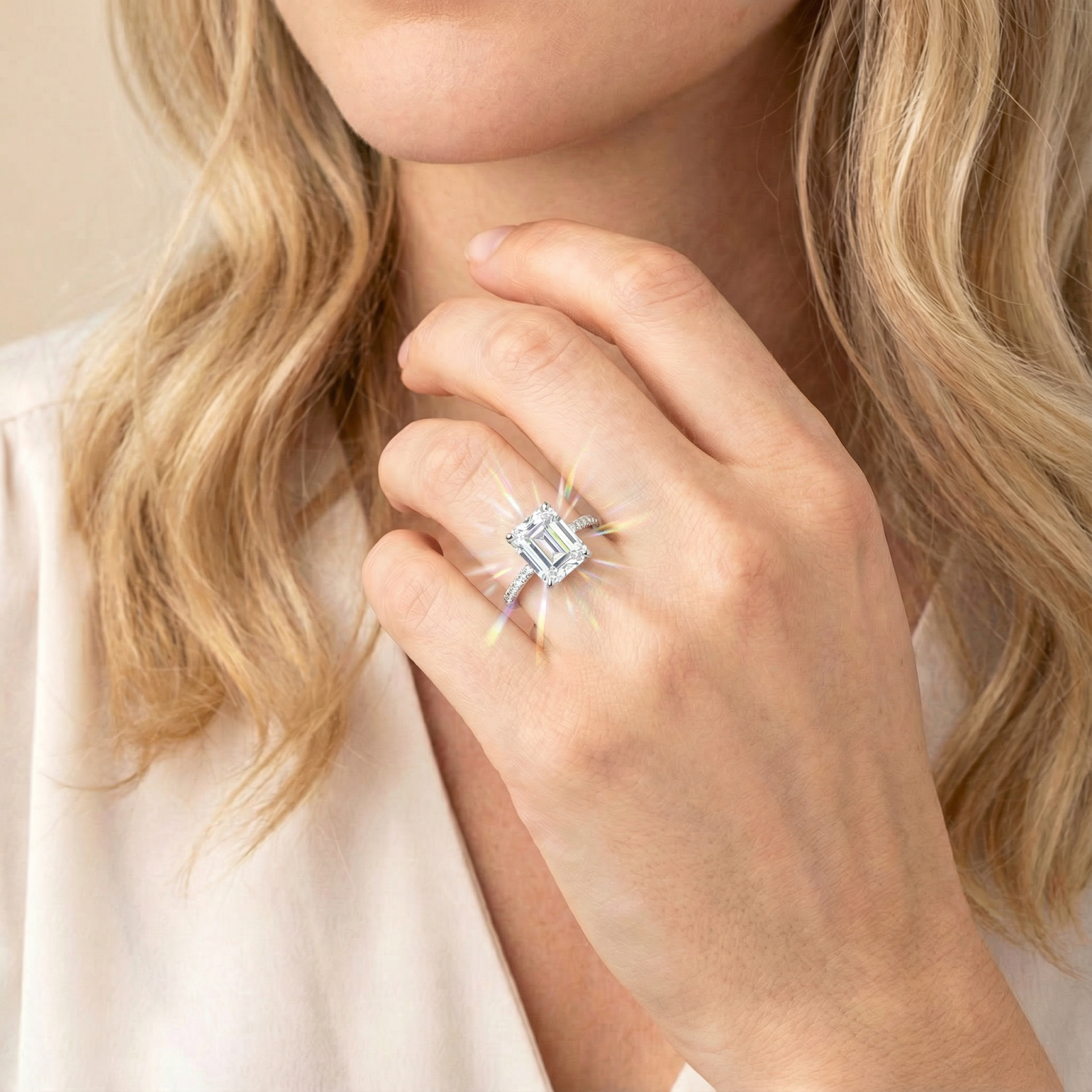 Emerald cut simulated diamond ring in sterling silver worn on a woman's hand with a sparkling light effect.