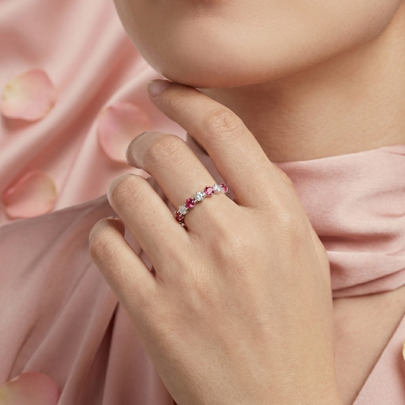 Close-up of a model wearing the sterling silver pink tourmaline and clear stone ring on her finger.