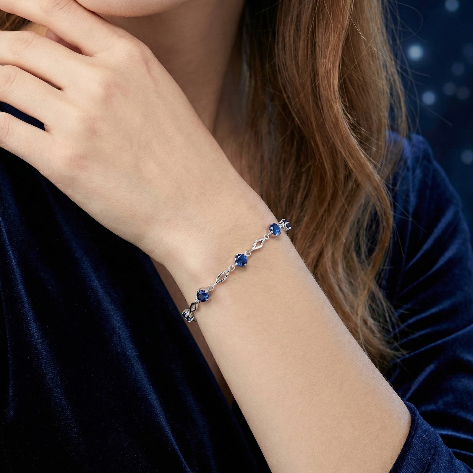 Close-up of the Nerienne blue sapphire and sterling silver station bracelet on a model's wrist.
