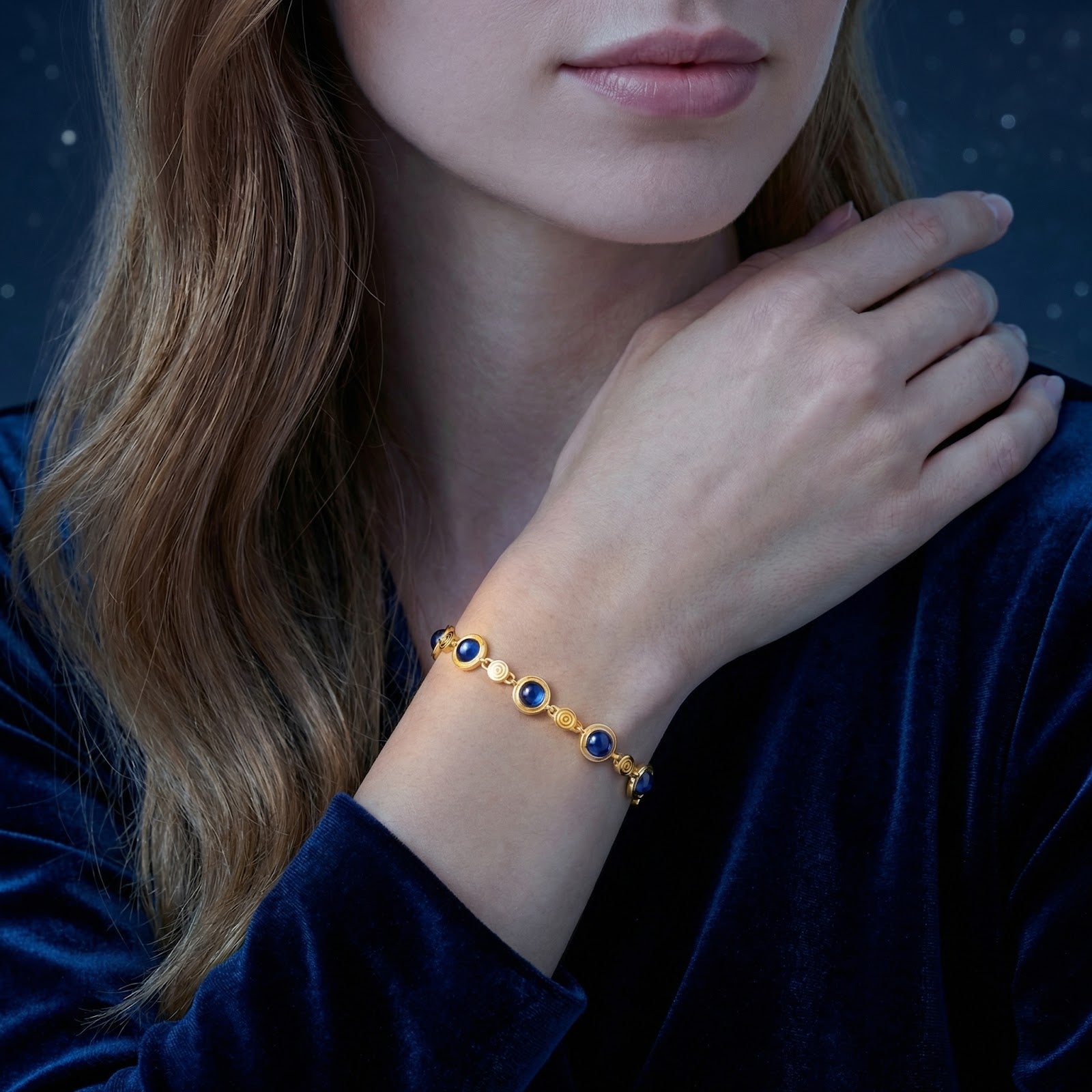 Woman wearing the 18K gold vermeil station bracelet with blue simulated sapphires on her wrist.