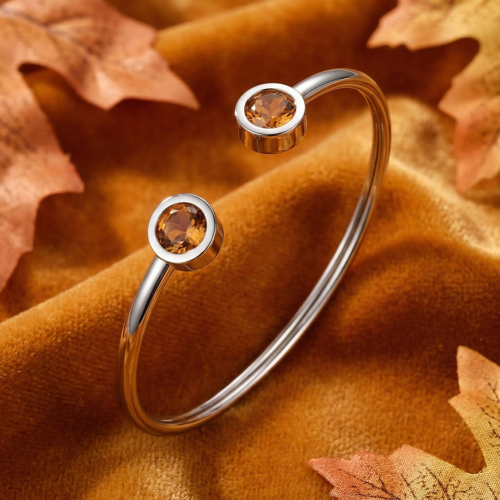 Silver stainless steel cuff bracelet with round simulated topaz stones on an autumn-themed velvet background.