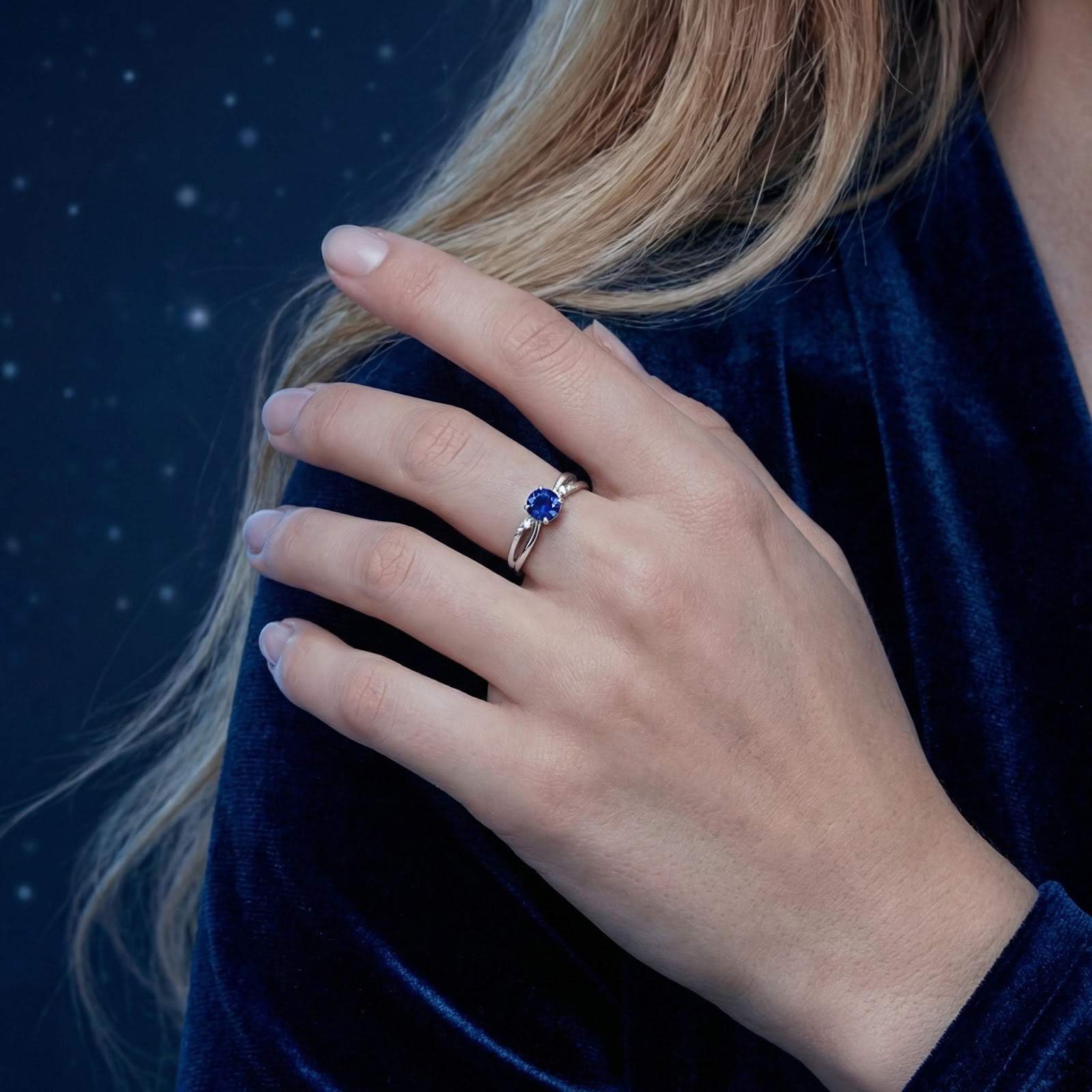 Model wearing the Isaraea S925 sterling silver twist ring with a round royal blue sapphire on her hand.