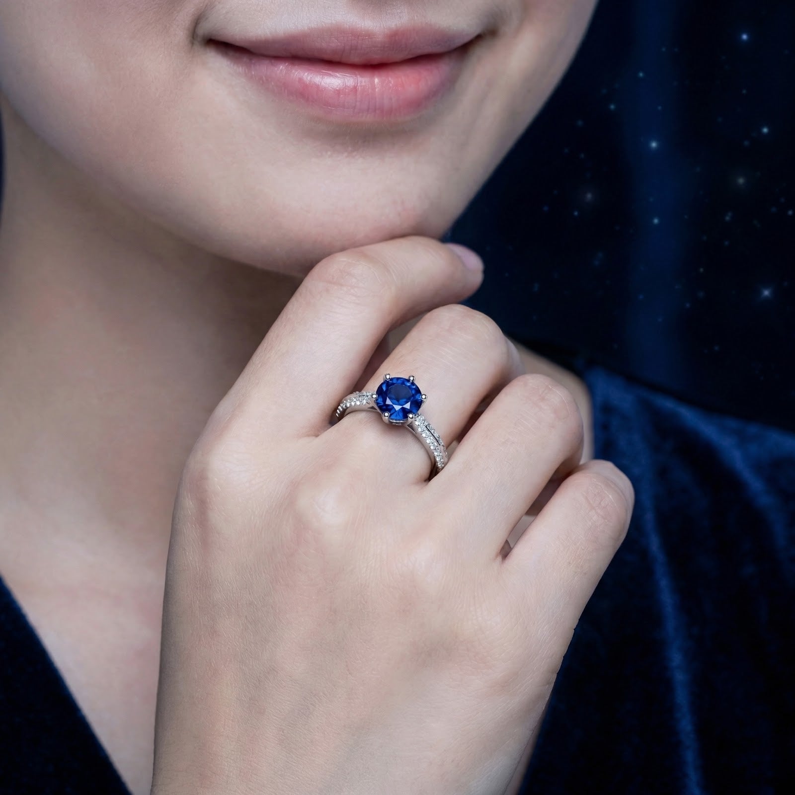 The Thalys solitaire ring with a round royal blue simulated sapphire worn on a woman's hand.