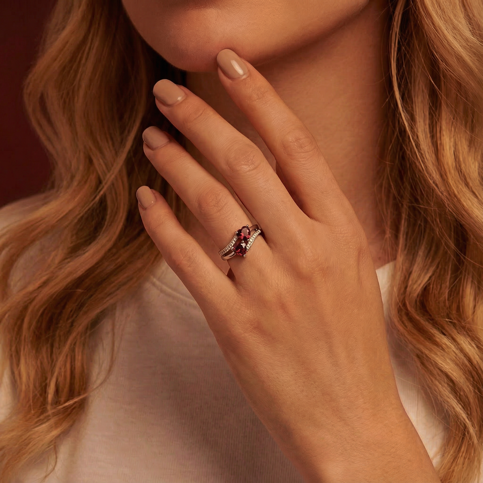 Model wearing the sterling silver Valery ring with two heart cut simulated garnets on her ring finger.