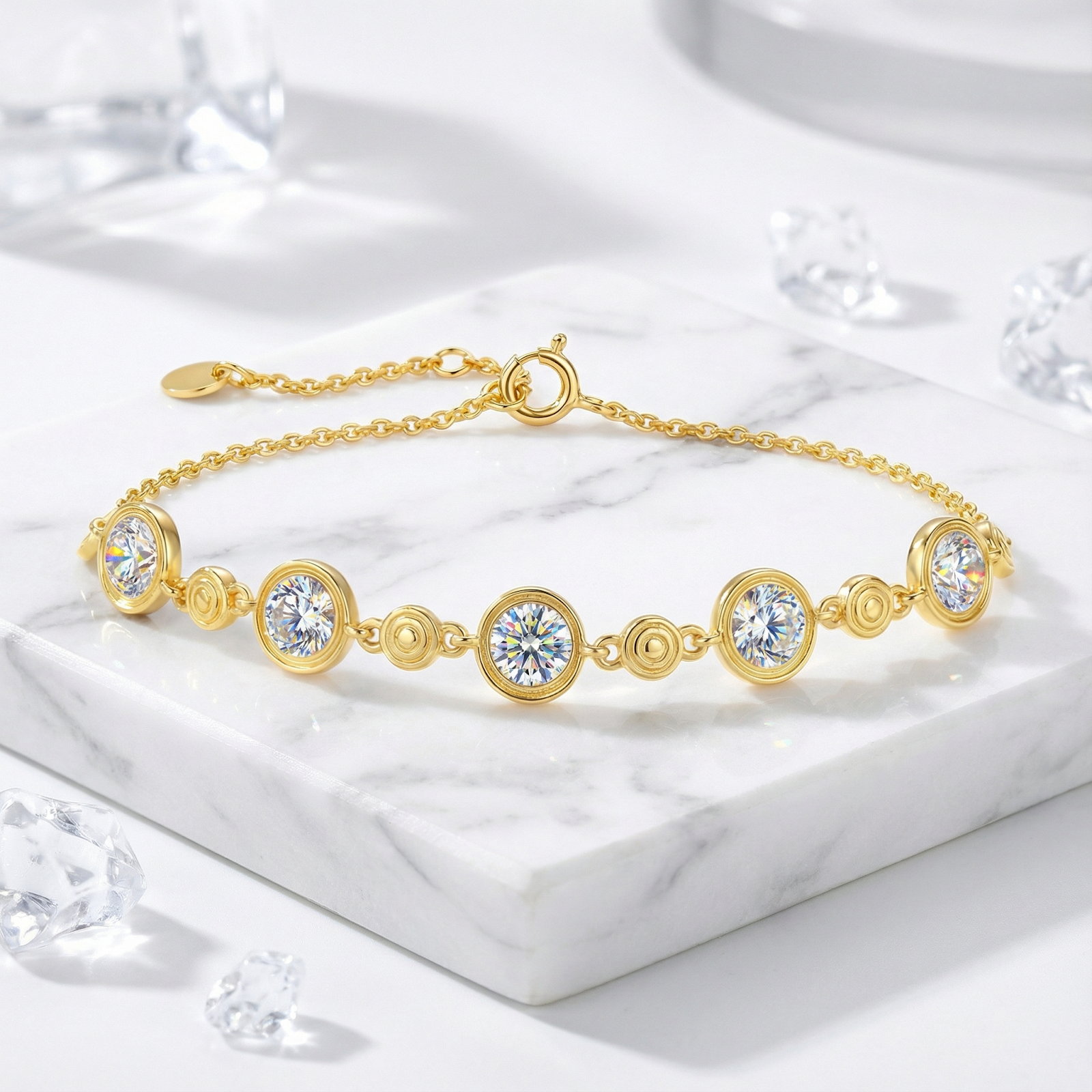 Gold vermeil station bracelet with five round simulated diamonds in bezel settings on a white marble surface.