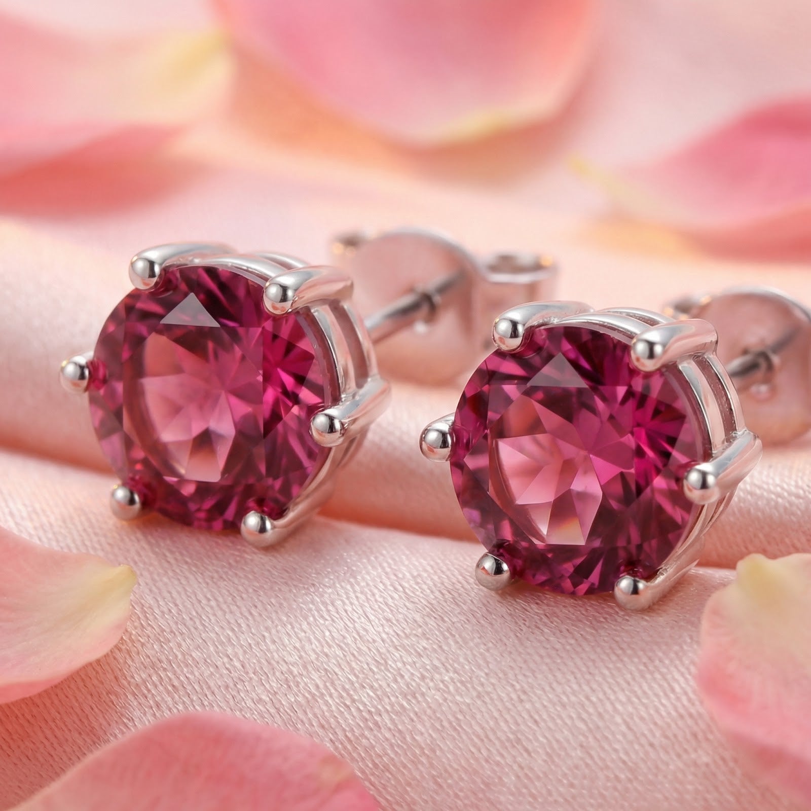 Close-up of round cut simulated pink tourmaline stud earrings in a sterling silver prong setting.