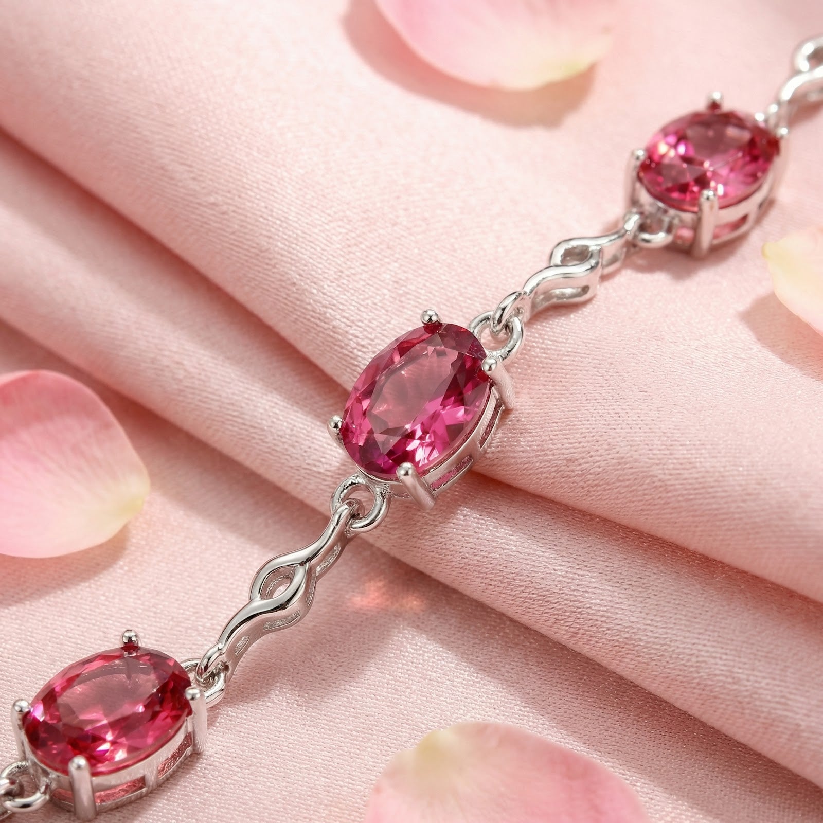 Close-up of oval-cut simulated pink tourmalines in S925 sterling silver prong settings.