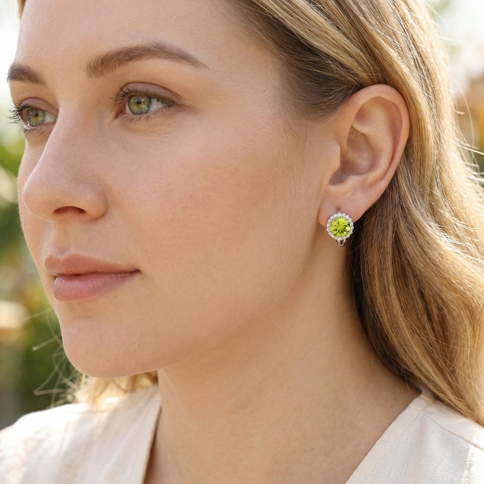 Woman wearing a green moissanite halo stud earring in S925 sterling silver for an elegant August birthstone look.