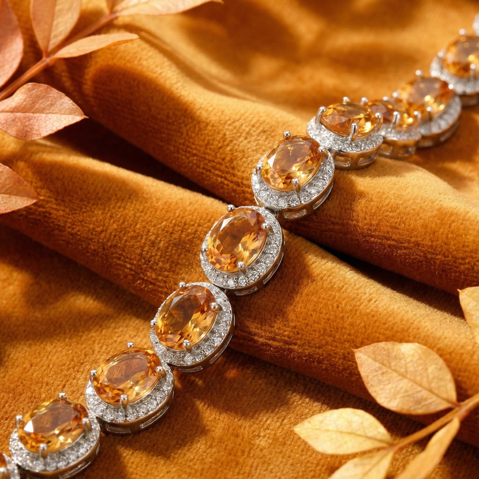 Close-up of the Alizae sterling silver bracelet showing faceted oval simulated topaz stones in halo settings.