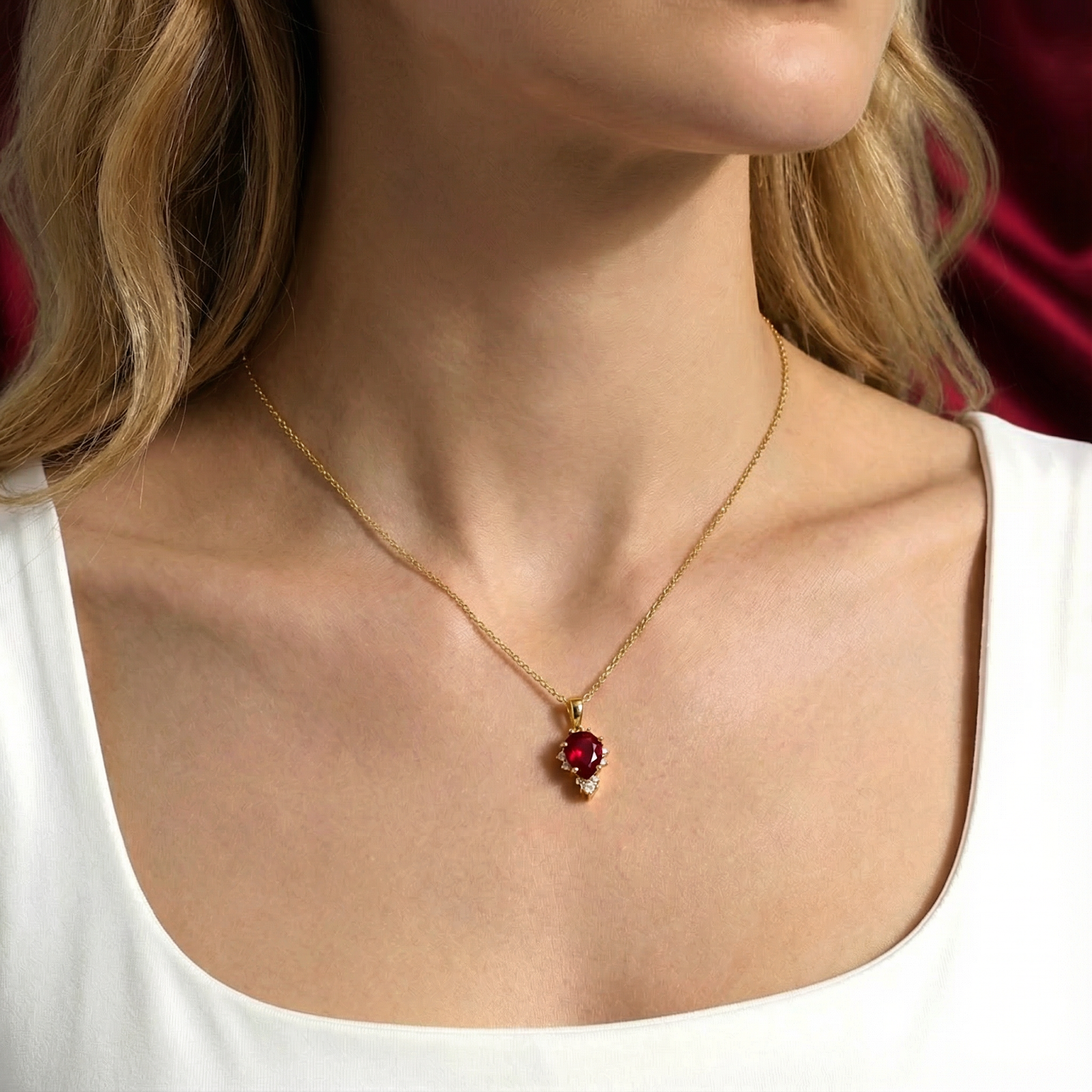 Model wearing the Mirellia pear cut simulated ruby necklace in 18K gold vermeil with a white top.
