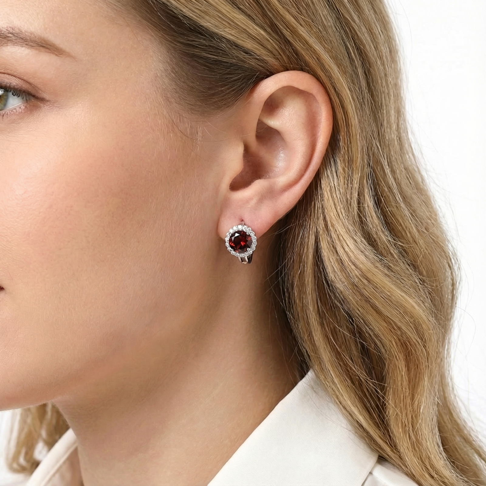 A woman wearing a round simulated garnet halo stud earring in S925 sterling silver to show the scale and fit.