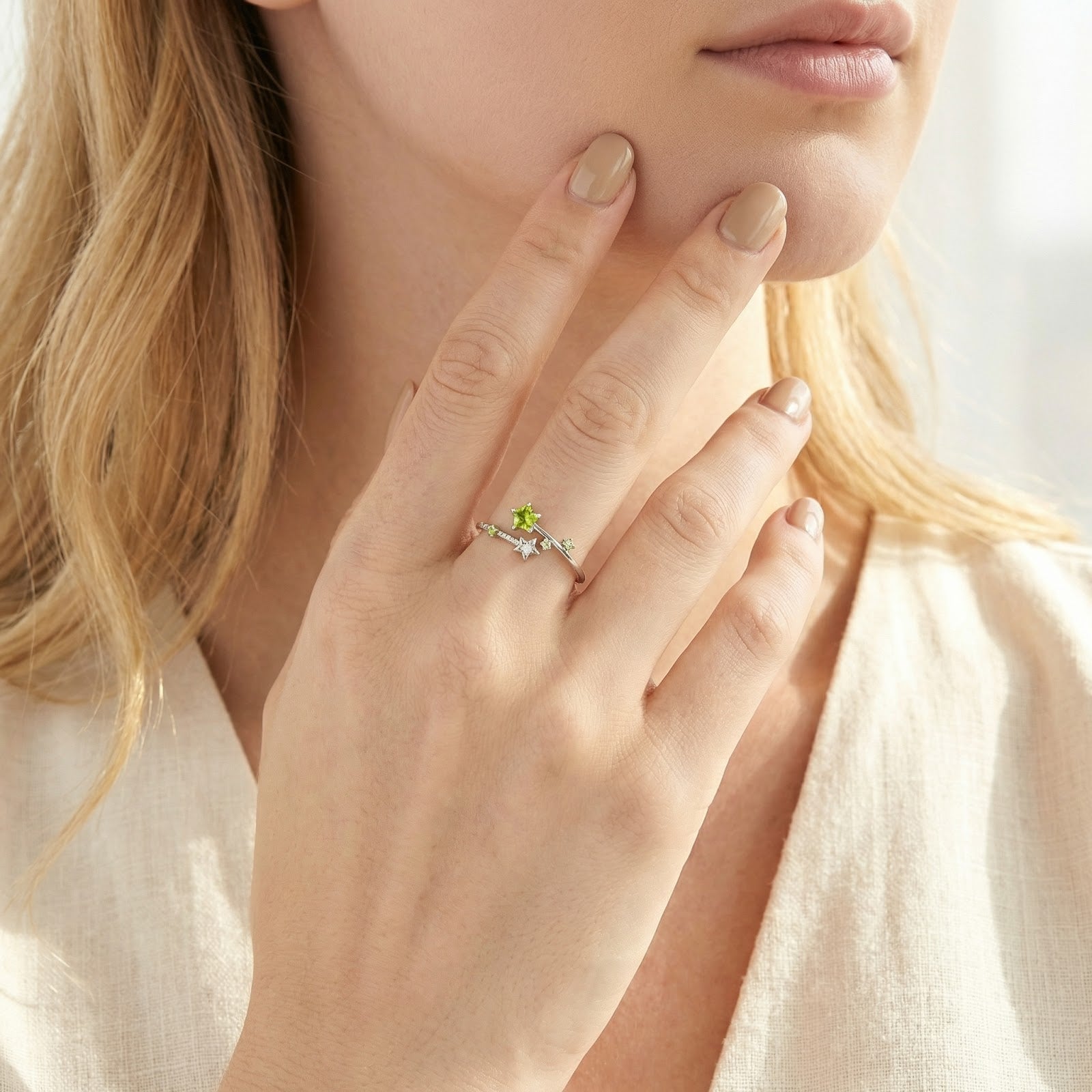 Woman wearing the sterling silver Stellina star bypass ring with vibrant lime green simulated peridot stones.