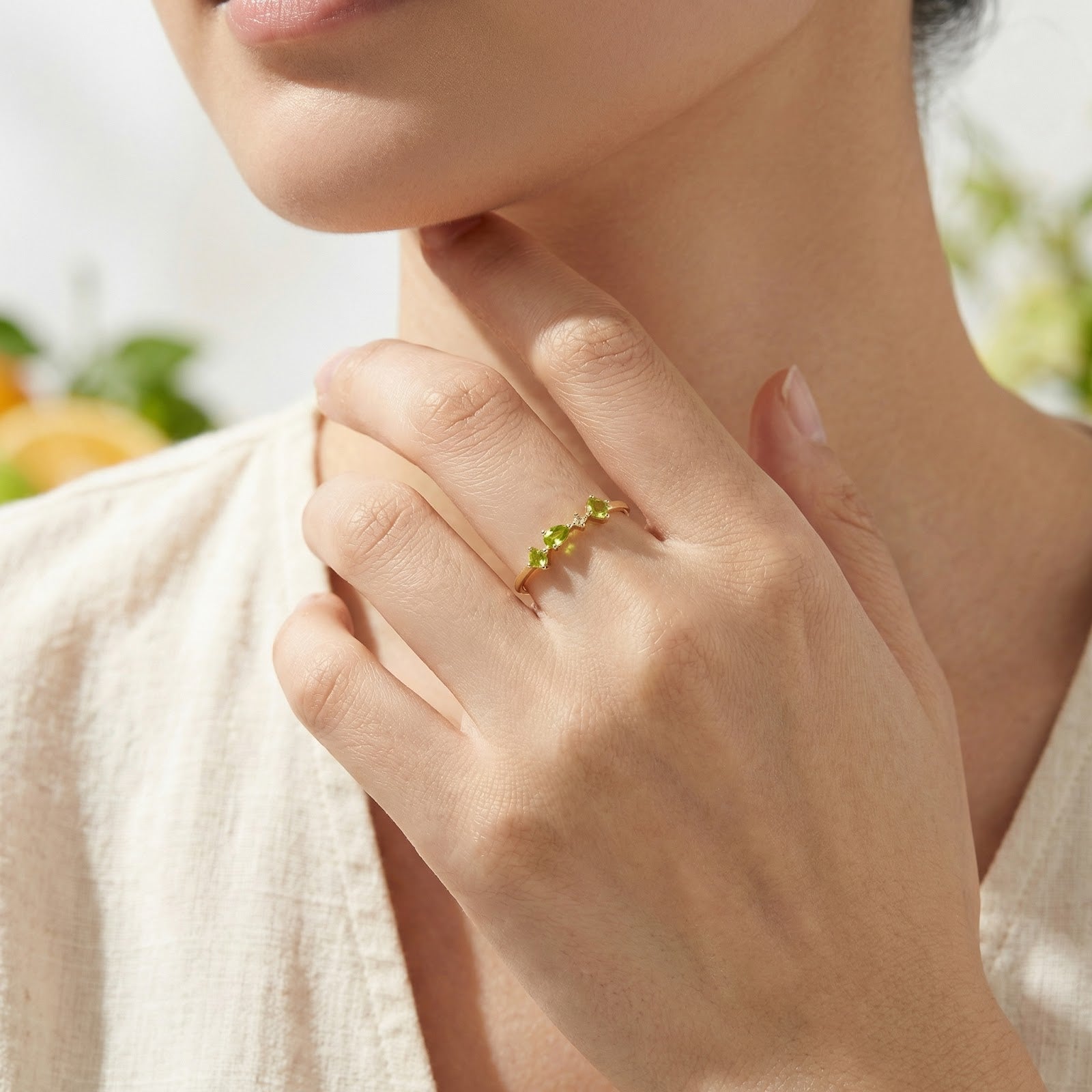 Model wearing the 18K gold vermeil simulated peridot ring on her ring finger, showcasing its delicate design.