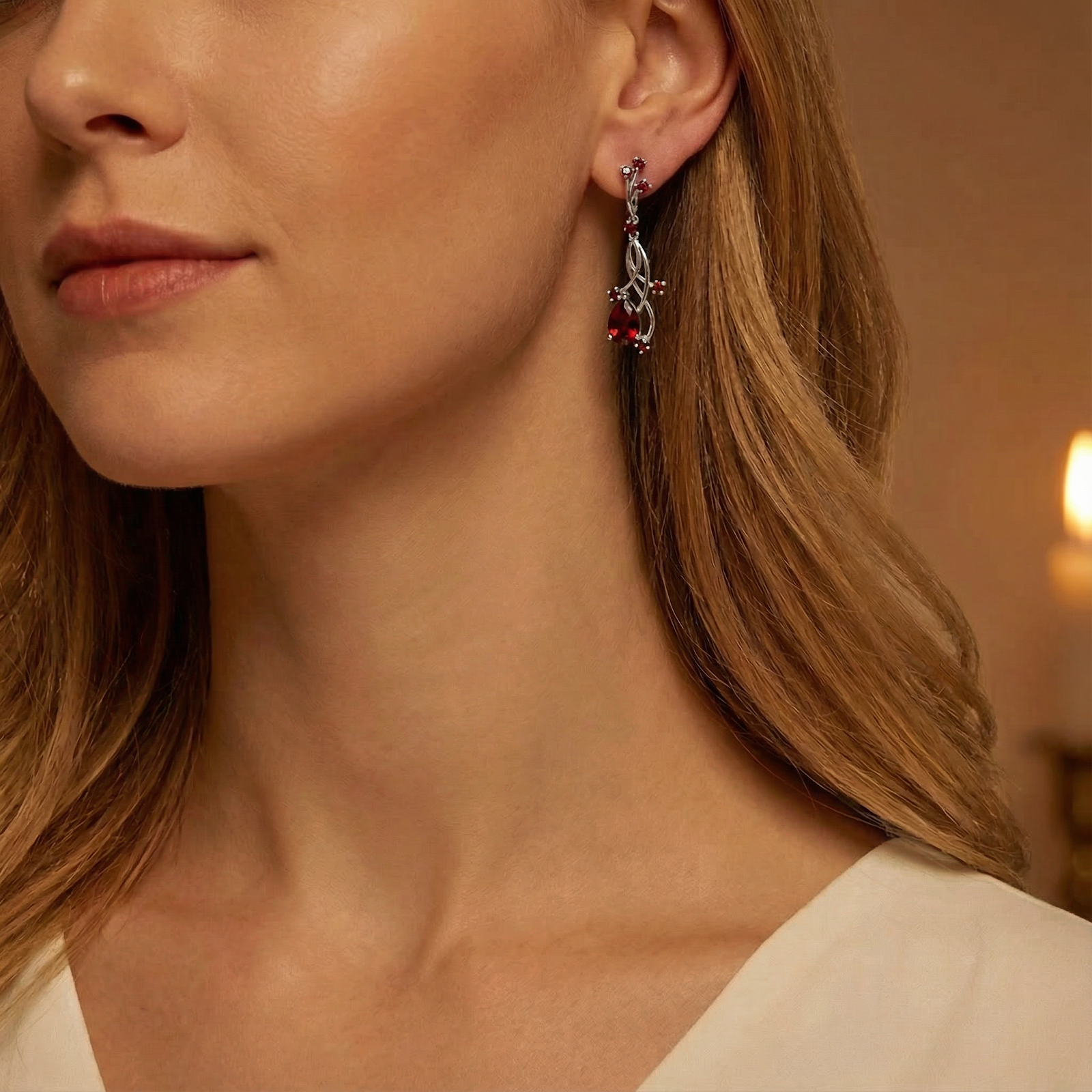 Model wearing the Kalina S925 sterling silver drop earring featuring vibrant red garnet stones.