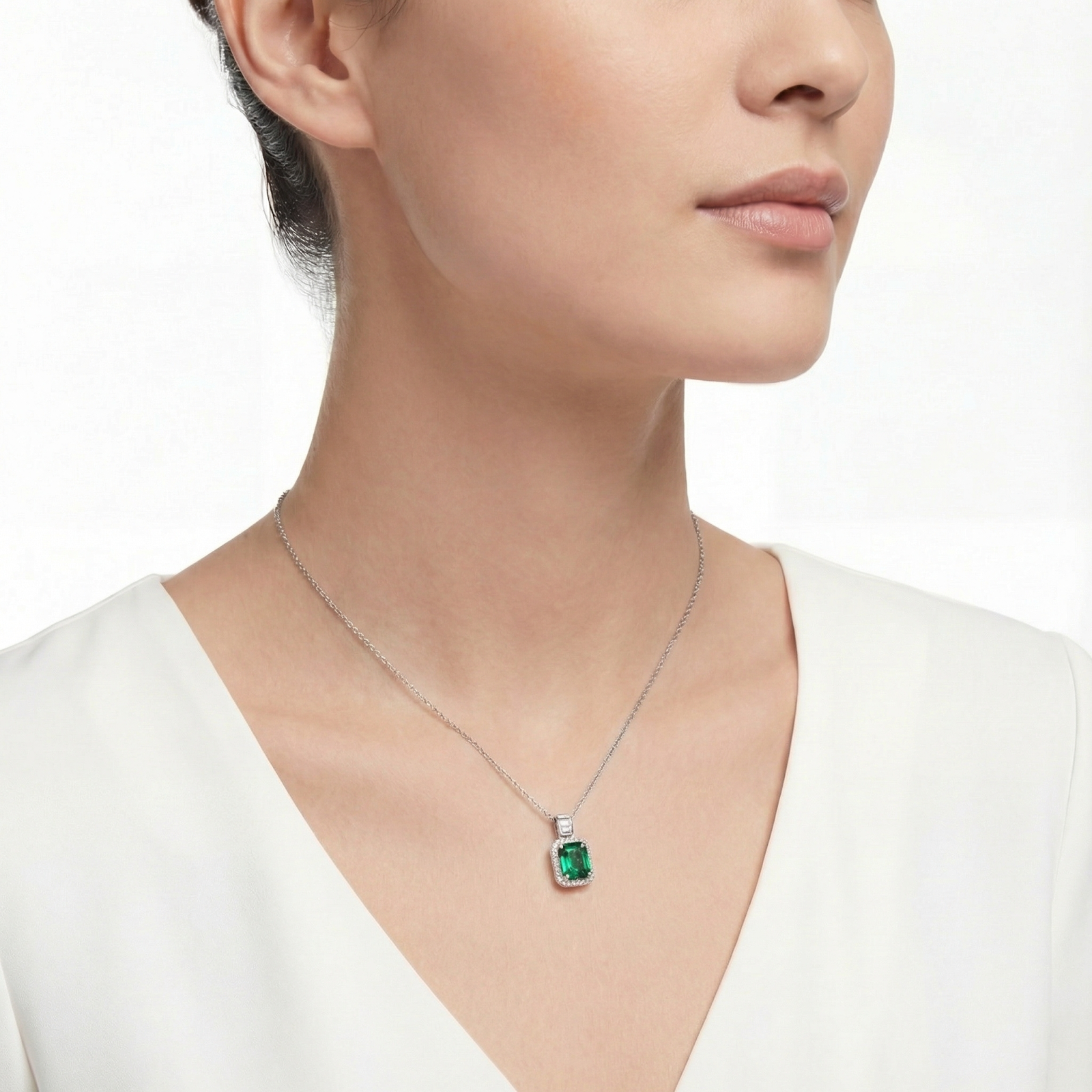 Side view of a model wearing the vivid green emerald-cut pendant necklace in rhodium-plated sterling silver.