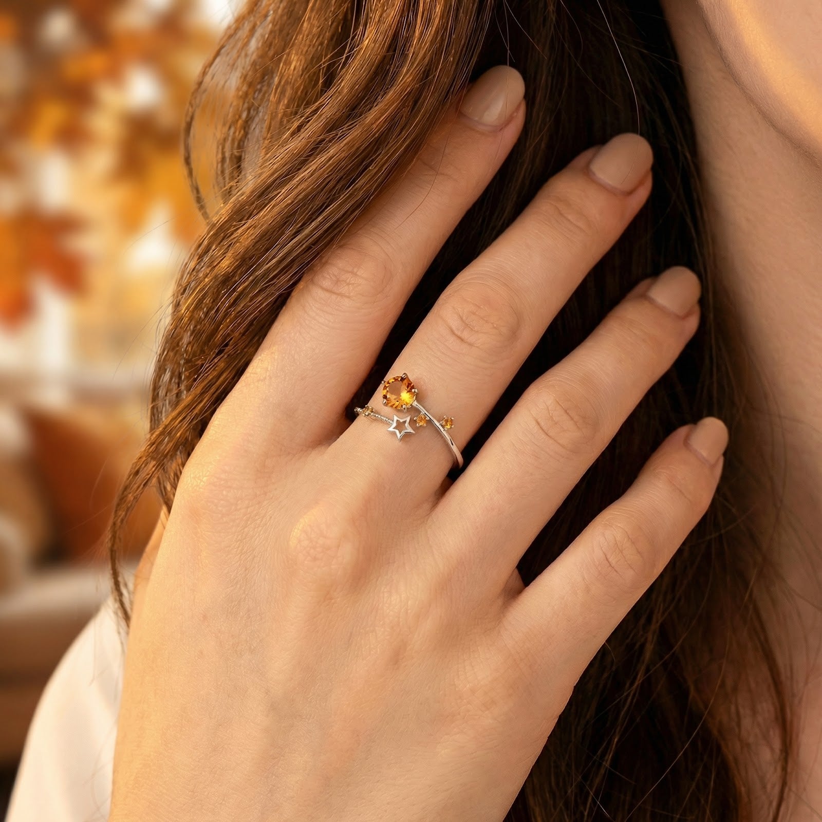 Sterling silver Astralis Star ring with golden simulated topaz worn on a woman's hand to show fit and scale.