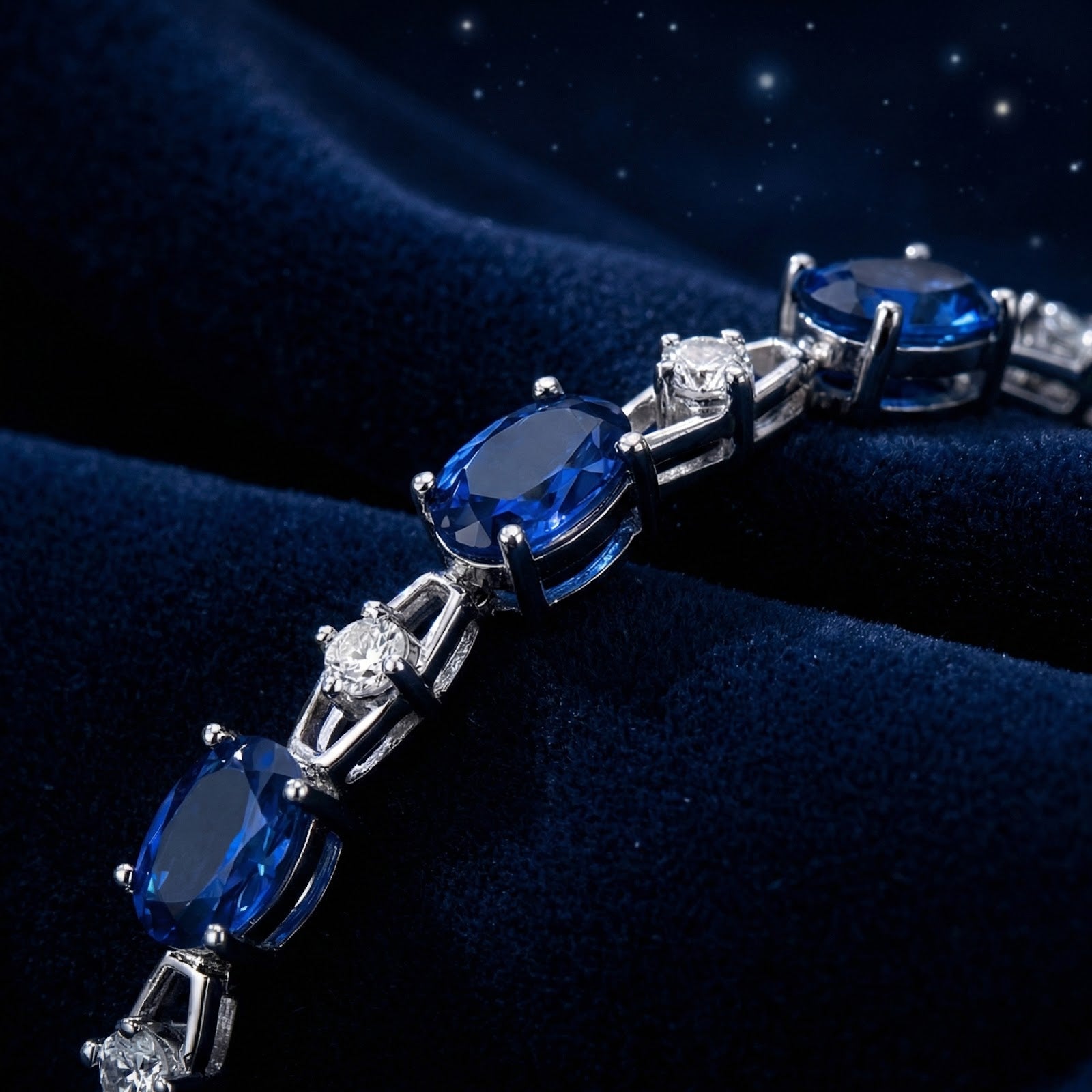 Macro shot of oval-cut simulated blue sapphires and round stones in a sterling silver bracelet setting.