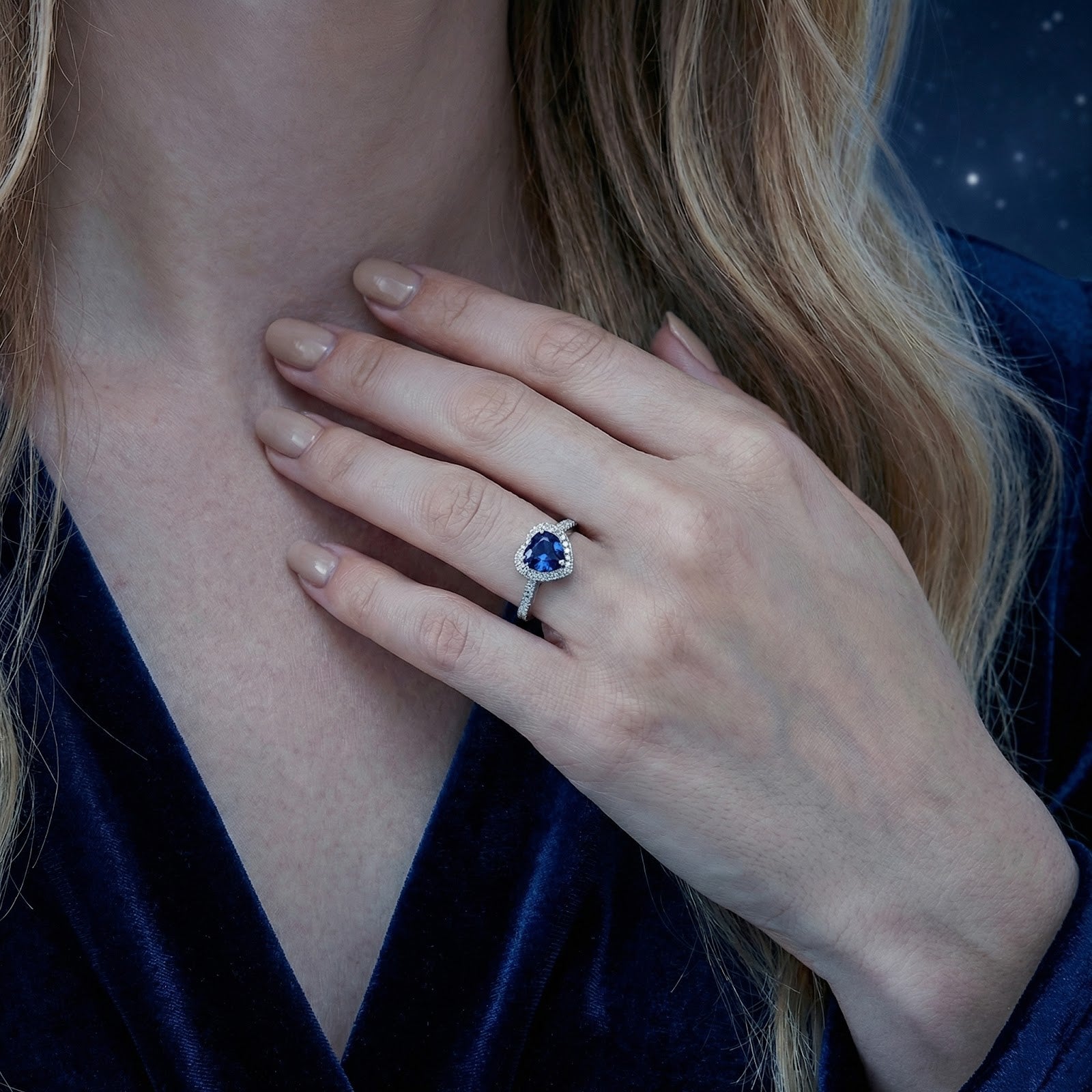 Close-up of a woman's hand wearing the S925 sterling silver heart-shaped blue sapphire ring.