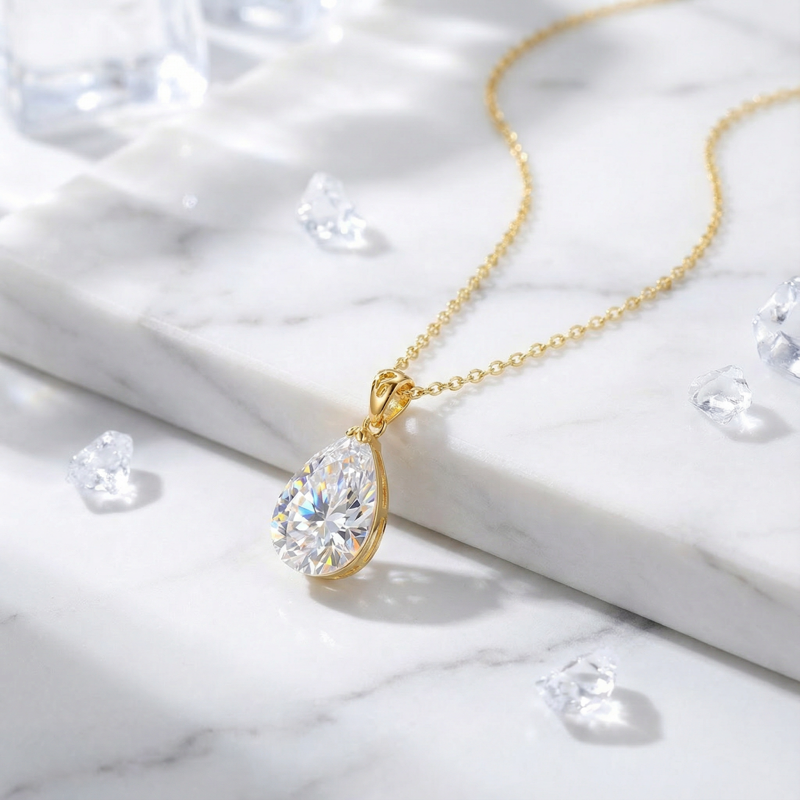 18K gold vermeil necklace with a pear-cut zirconia pendant displayed on a white marble surface.