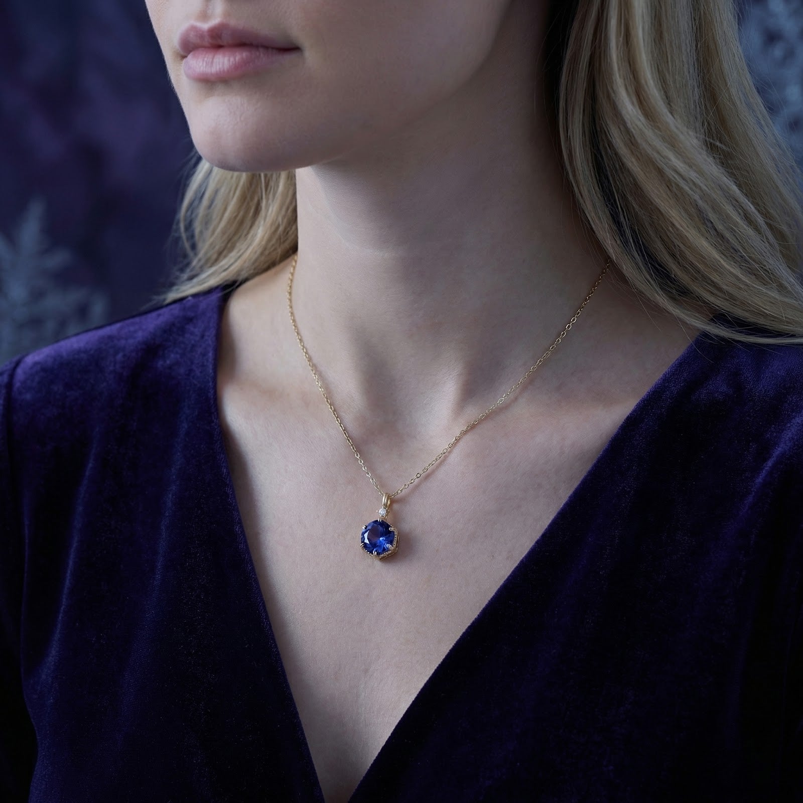Close-up of a model wearing the December birthstone simulated tanzanite necklace in 18K gold vermeil.