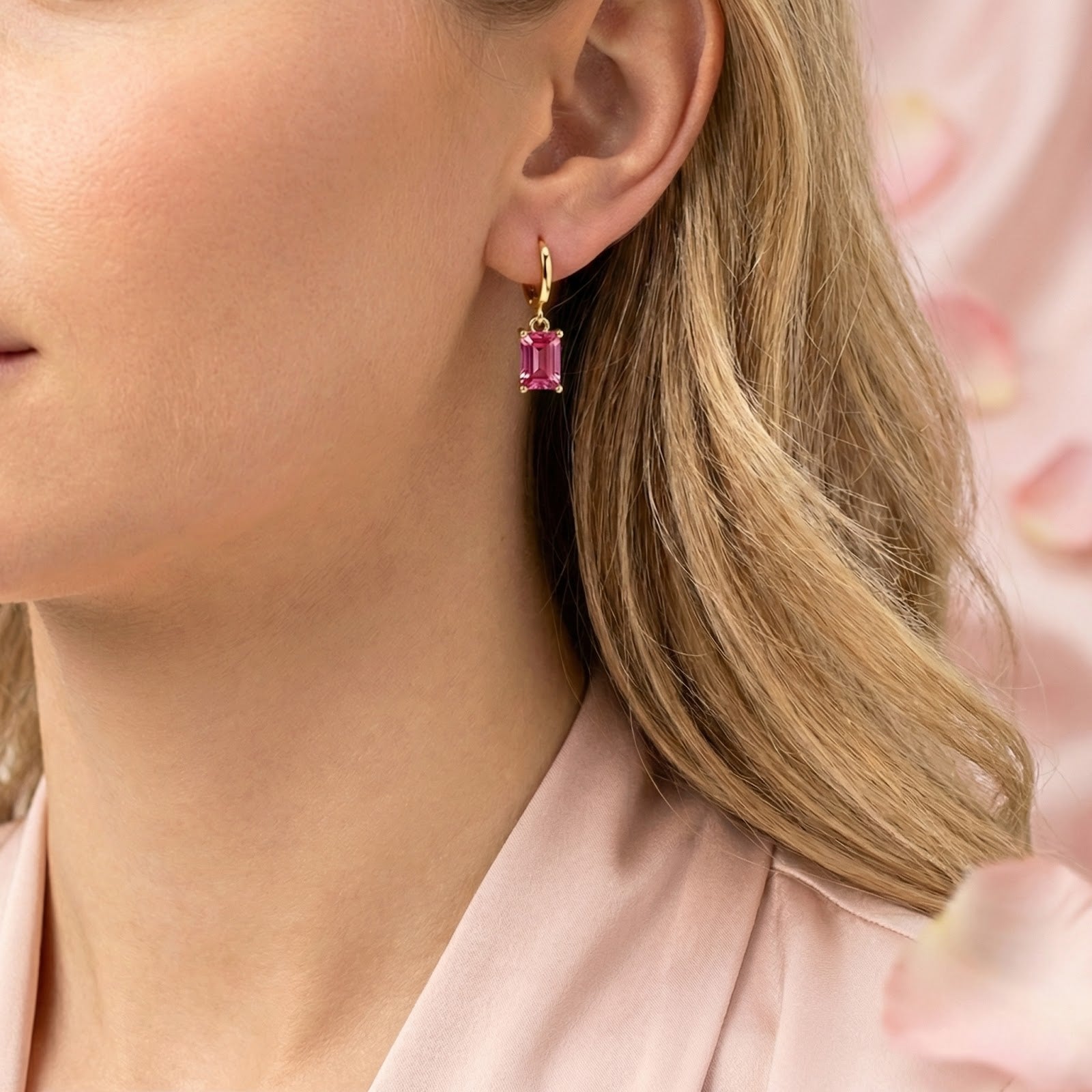 Side profile of a woman wearing gold vermeil emerald-cut pink tourmaline drop earrings.