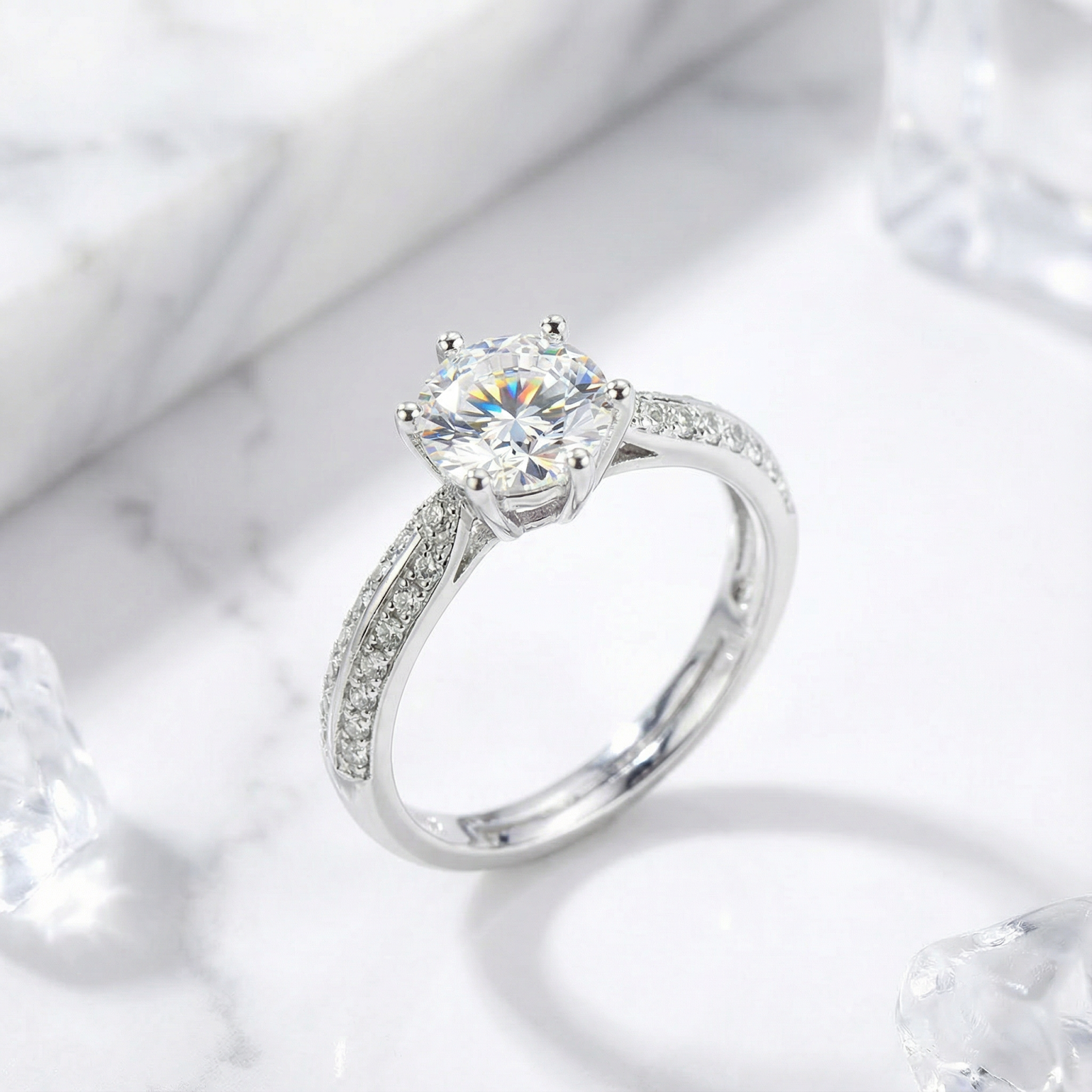 Angled view of the Kalysta round simulated diamond solitaire ring in sterling silver on a marble background.