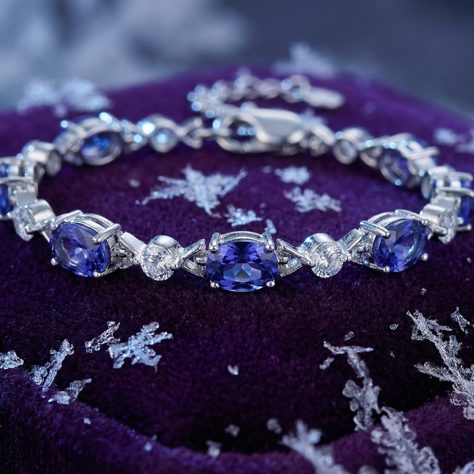 Close-up of faceted oval simulated tanzanite stones in a sterling silver bracelet setting.