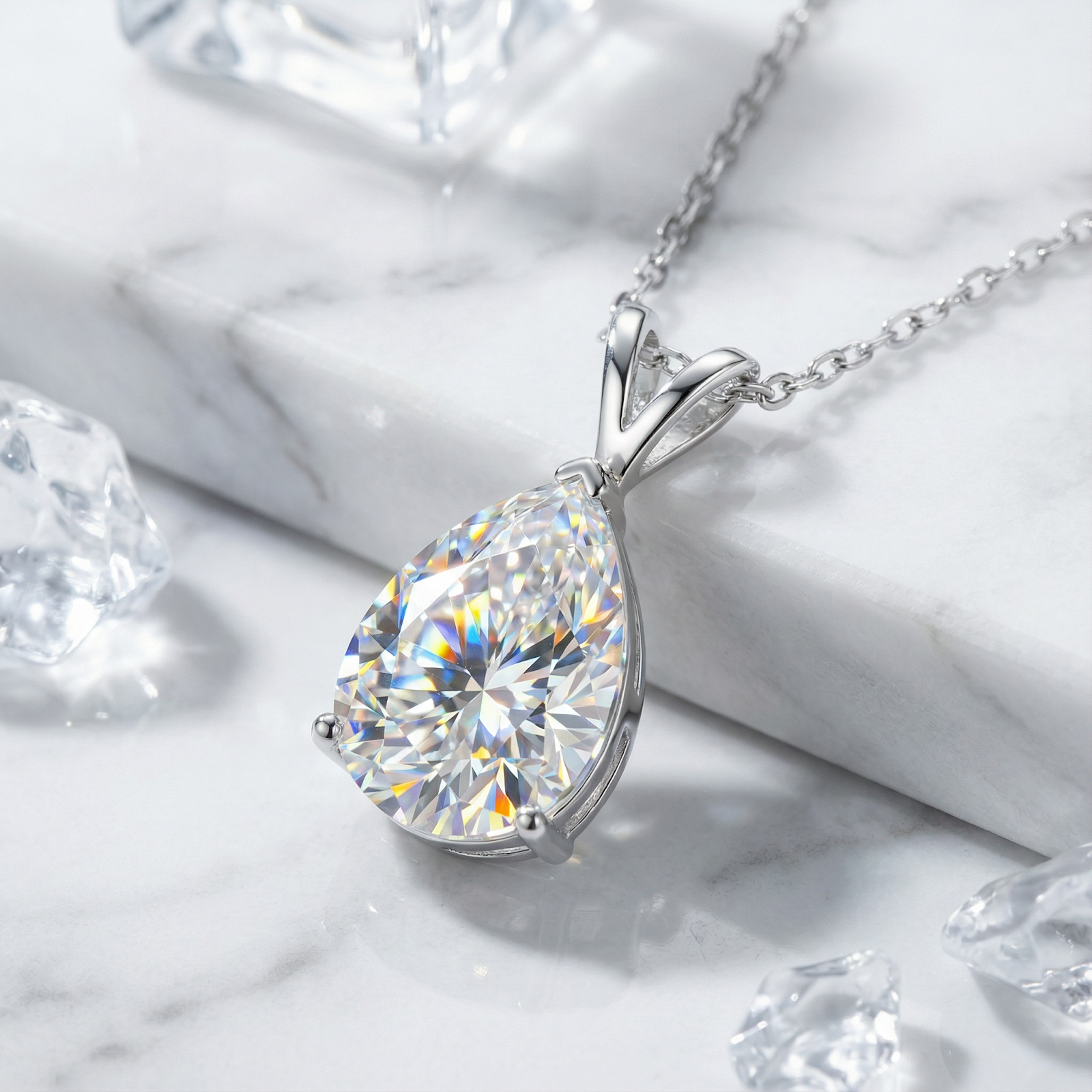 Close-up of a 1.5CT pear-cut moissanite pendant in a silver V-bale setting, showing brilliant light refraction.