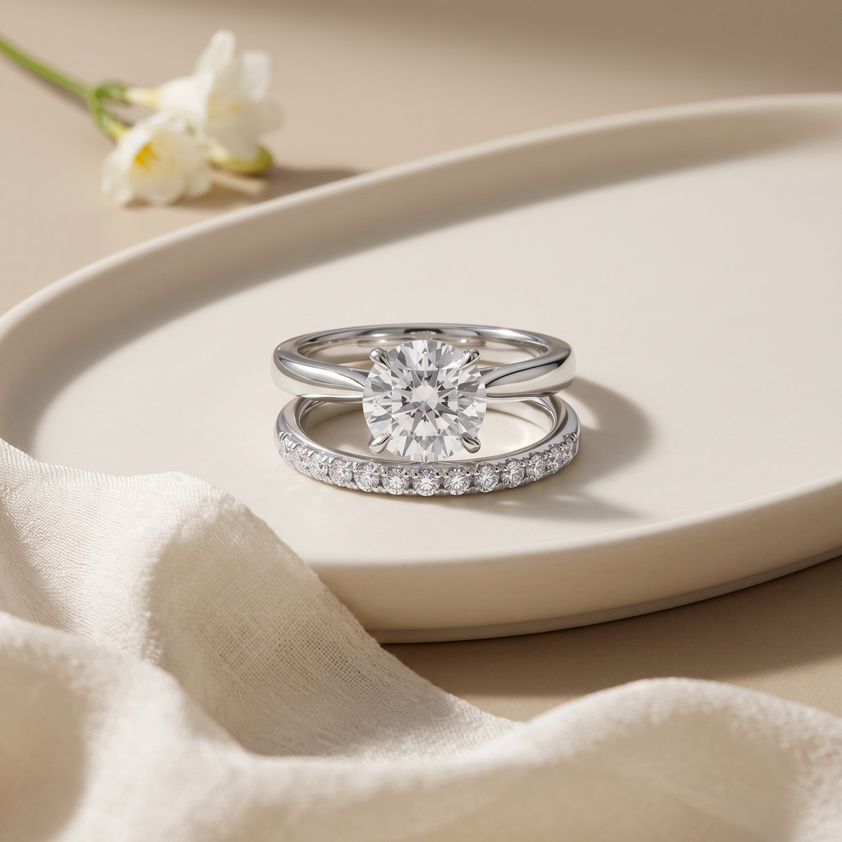 Round-cut moissanite solitaire and separate pavé band in silver, front product view.