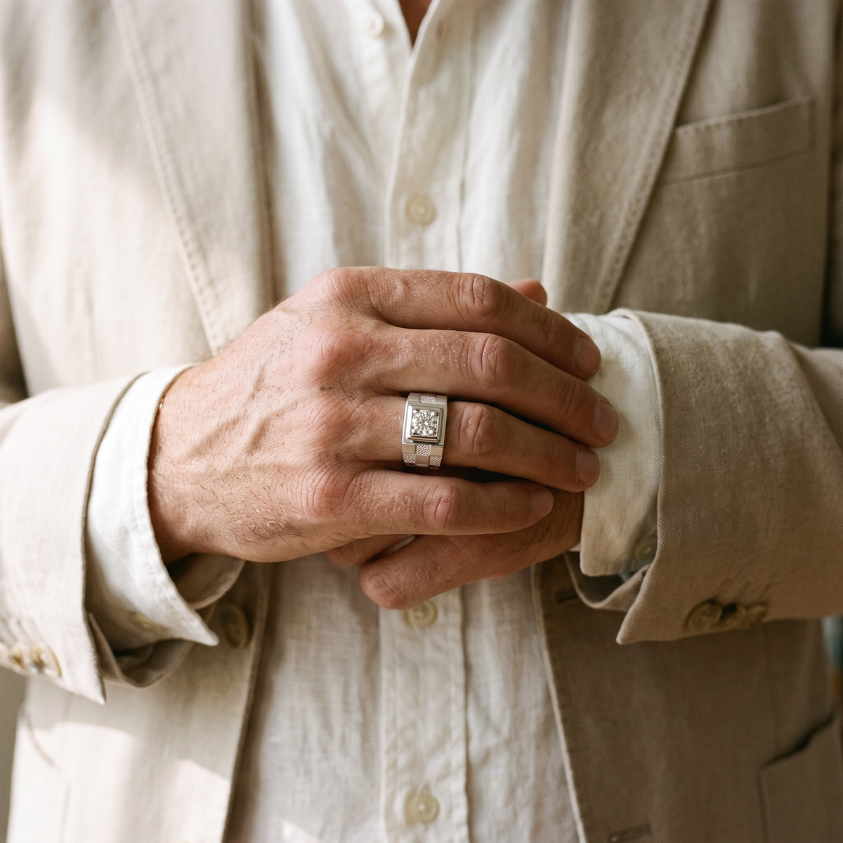 Silver checkered moissanite ring worn by a male model, cuff detail