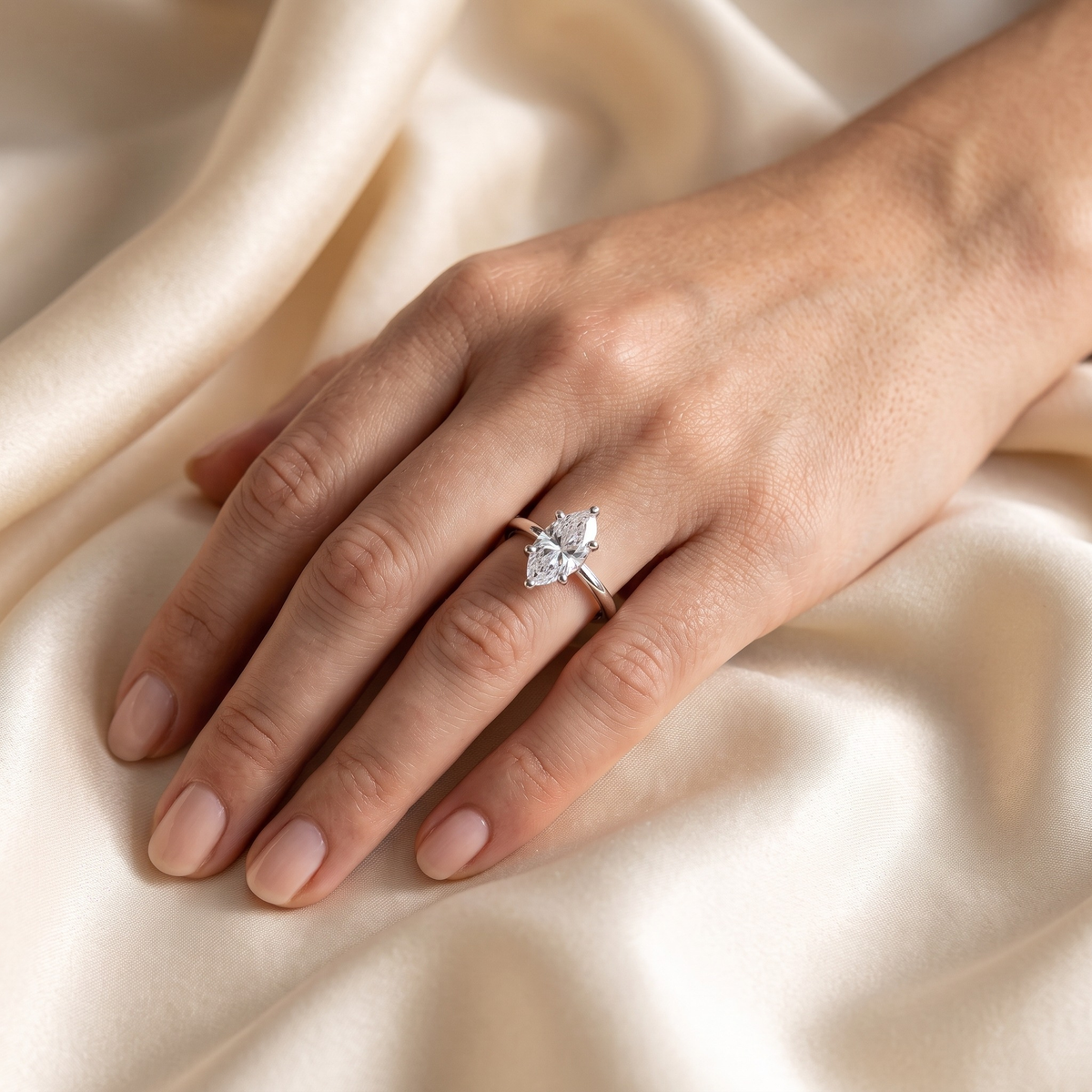 Silver marquise moissanite solitaire worn on a model hand