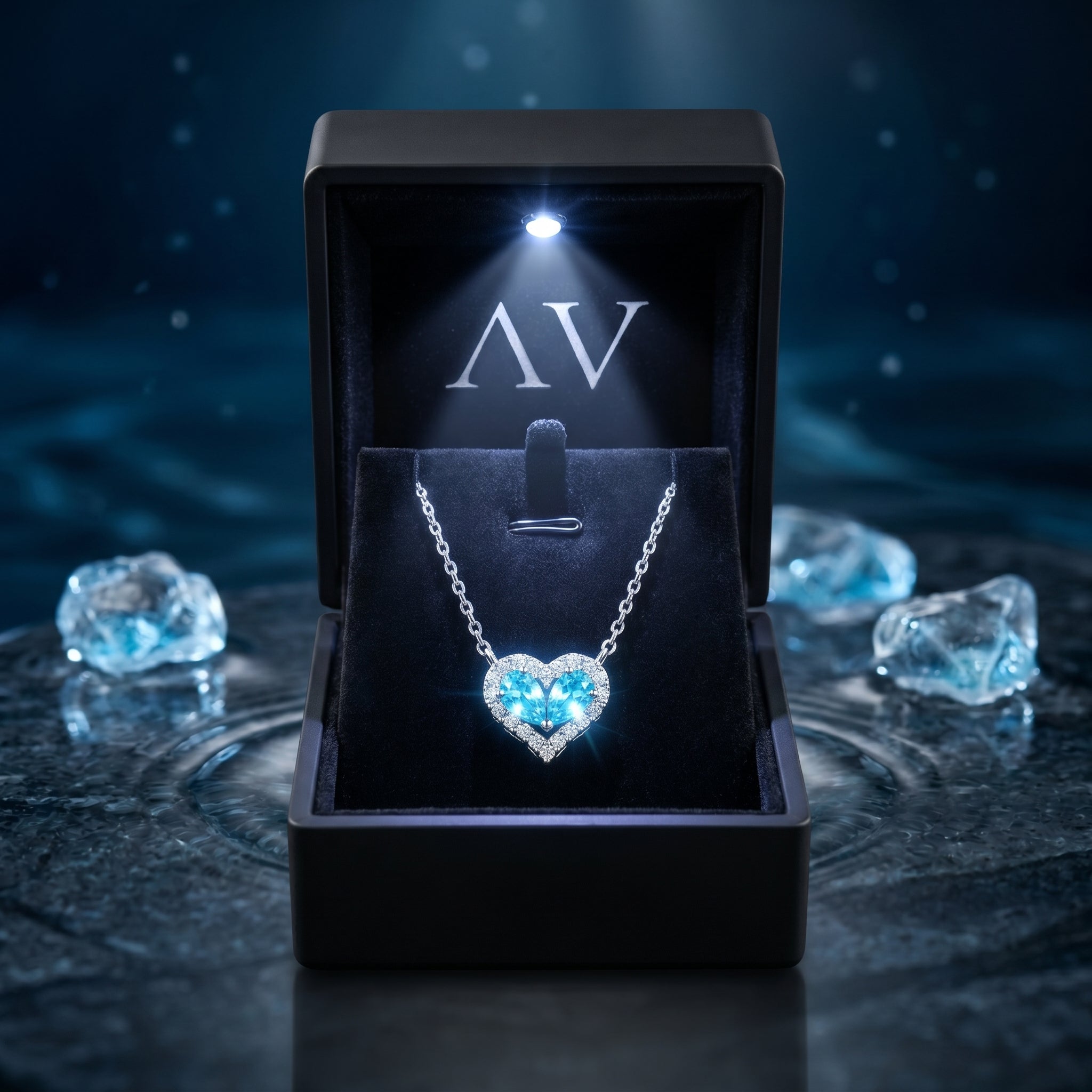 Silver aquamarine heart necklace displayed in a black jewelry box with a built-in LED spotlight.