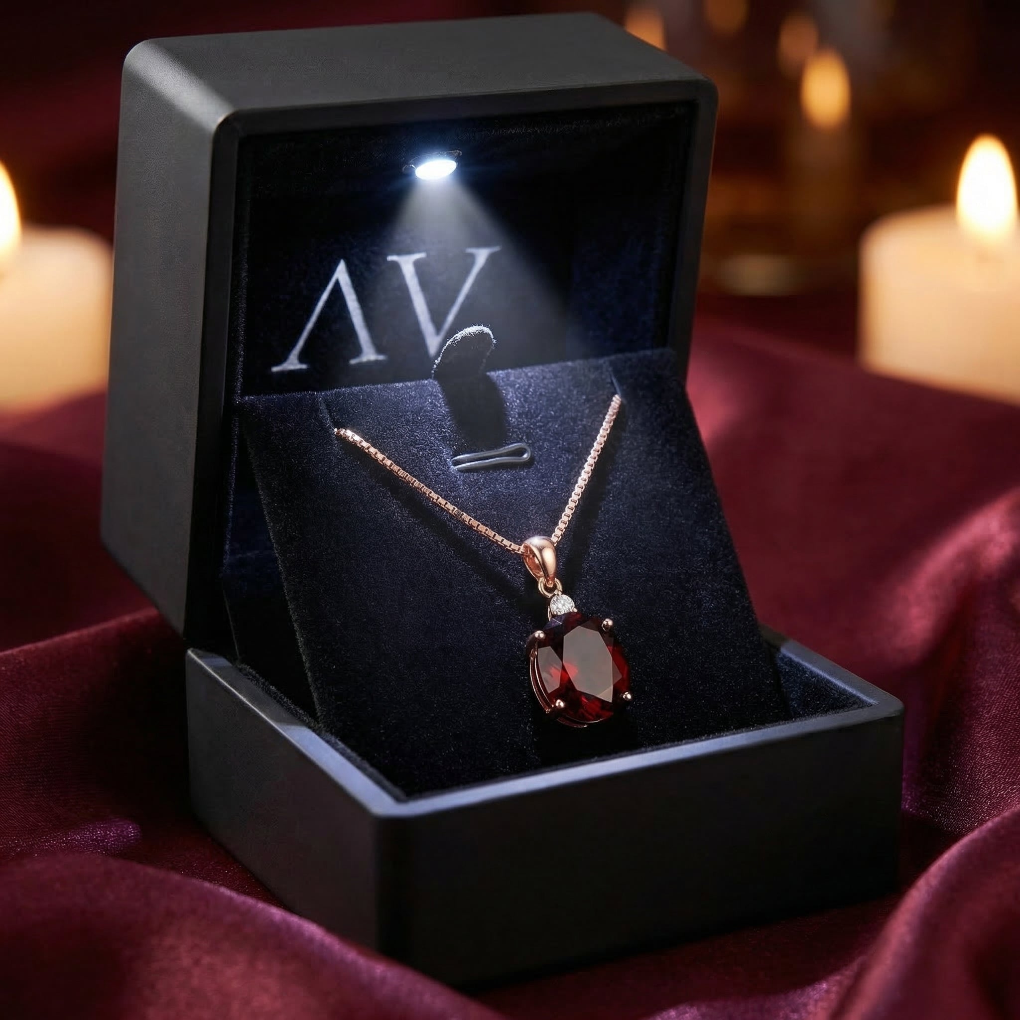 18K rose gold oval garnet necklace displayed in a black luxury gift box with an integrated LED spotlight.