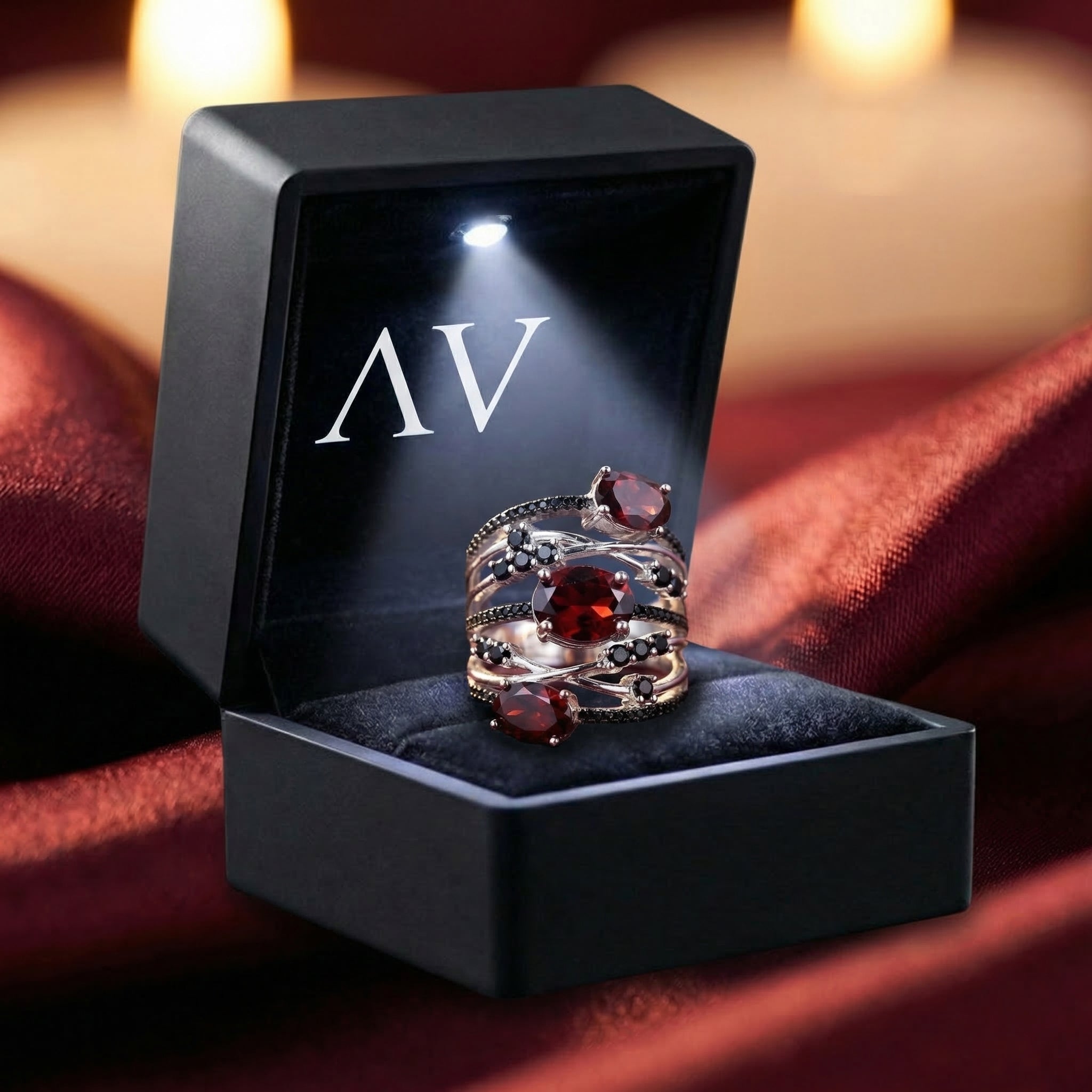 Odelia Trinity red garnet silver ring presented in a black LED-lit gift box with AV branding on silk.