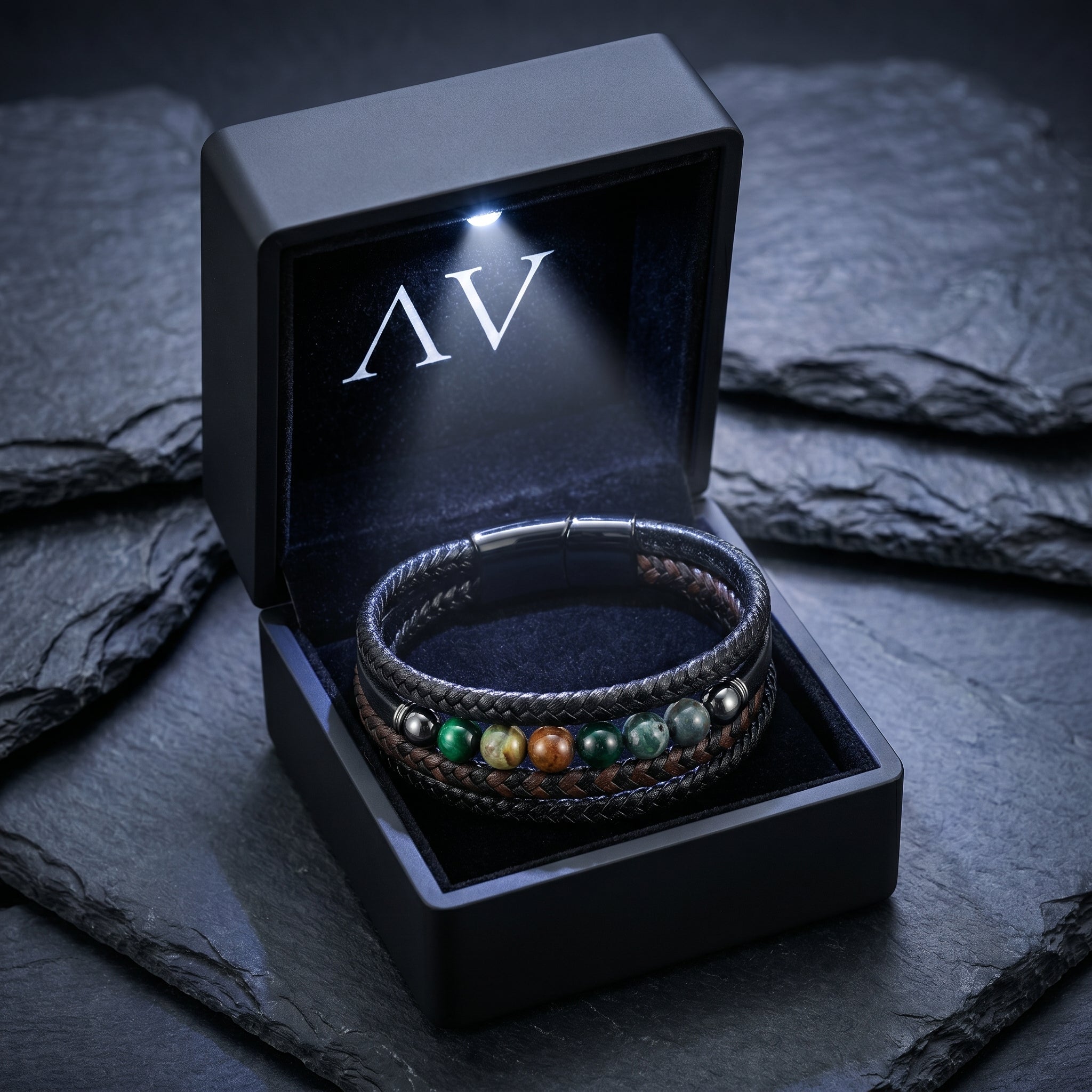 Black leather bracelet with natural stone beads in a premium LED-lit gift box on a slate background.