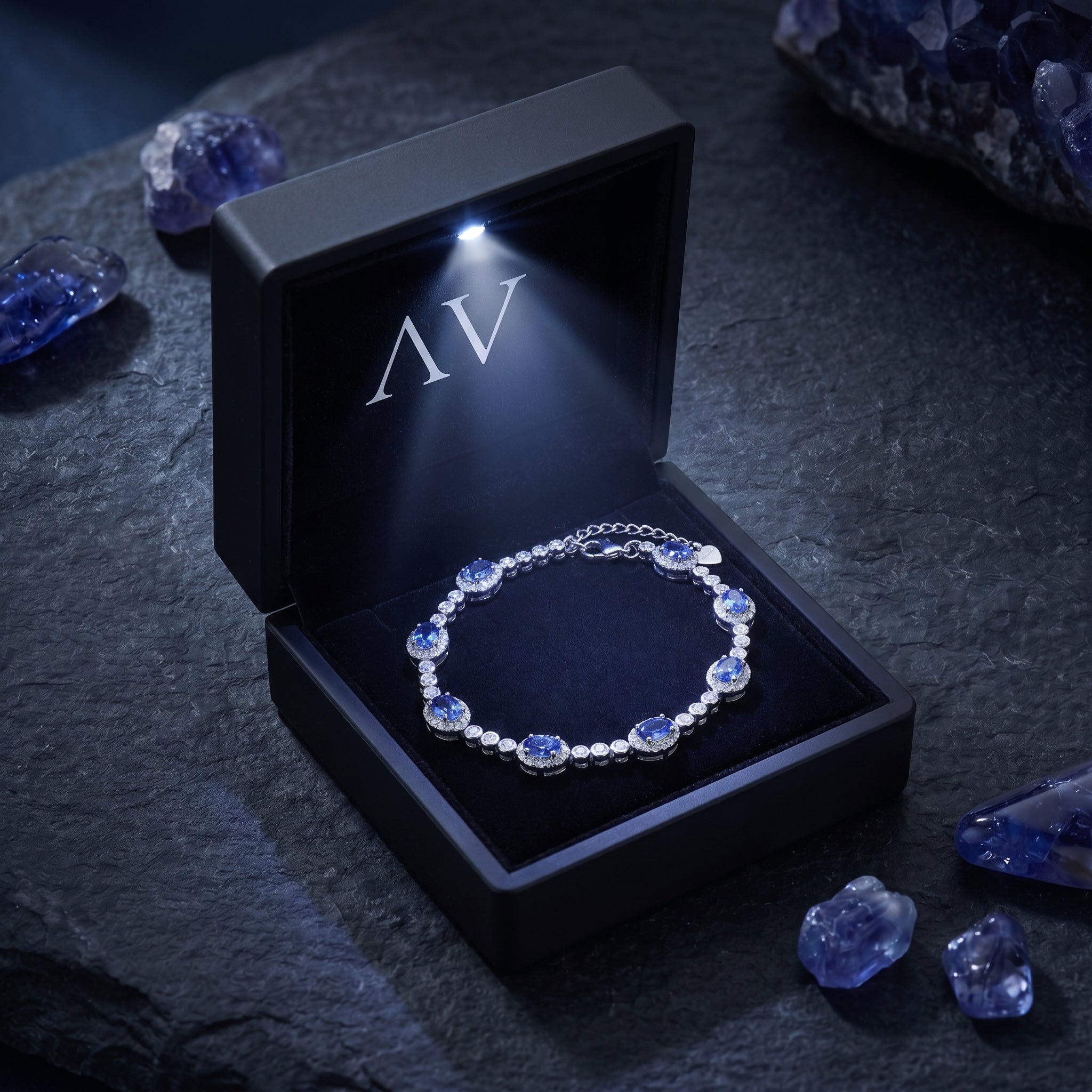 Natural tanzanite sterling silver line bracelet presented in a black illuminated gift box with an LED light.