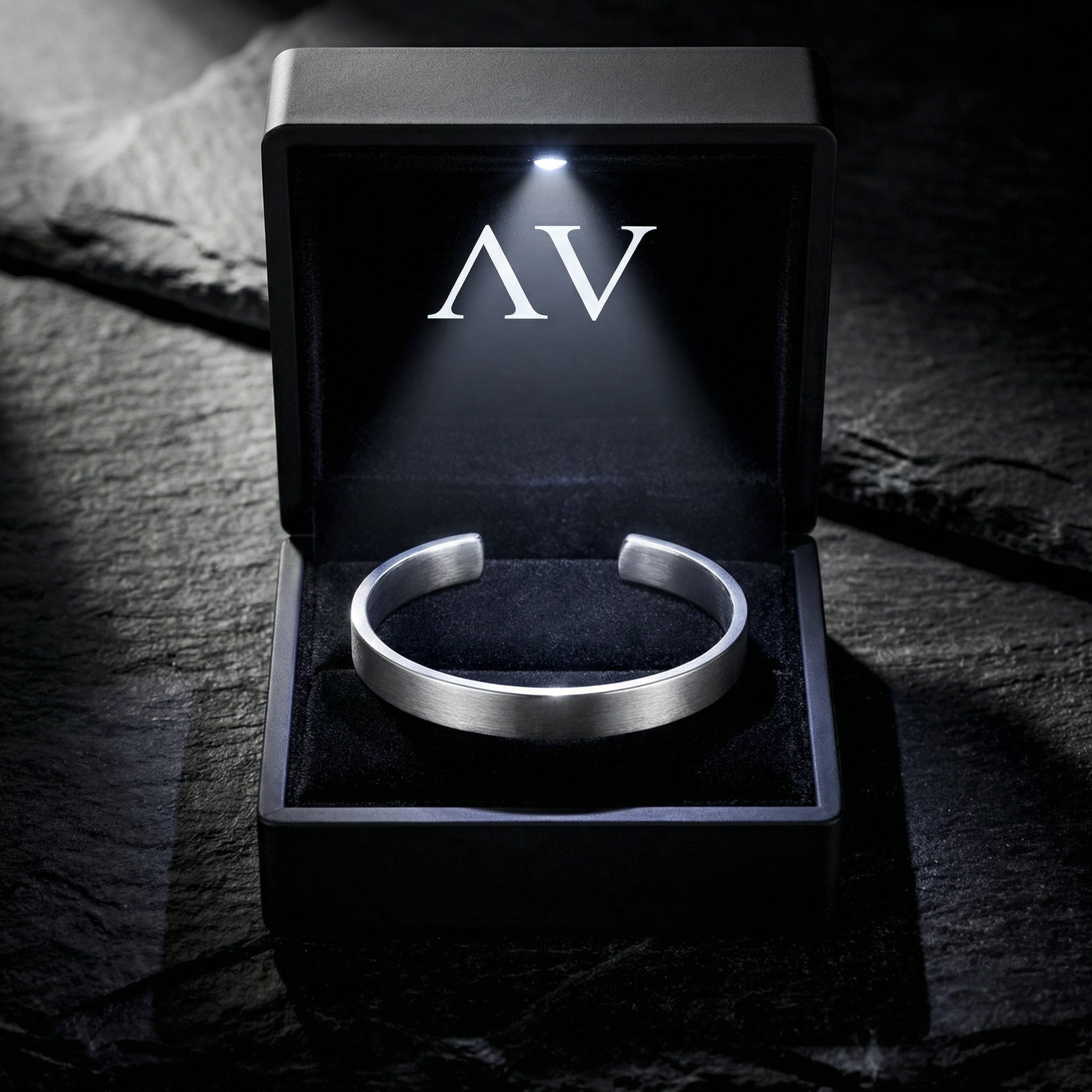 Silver stainless steel cuff bracelet inside a black LED-lit jewelry presentation box.