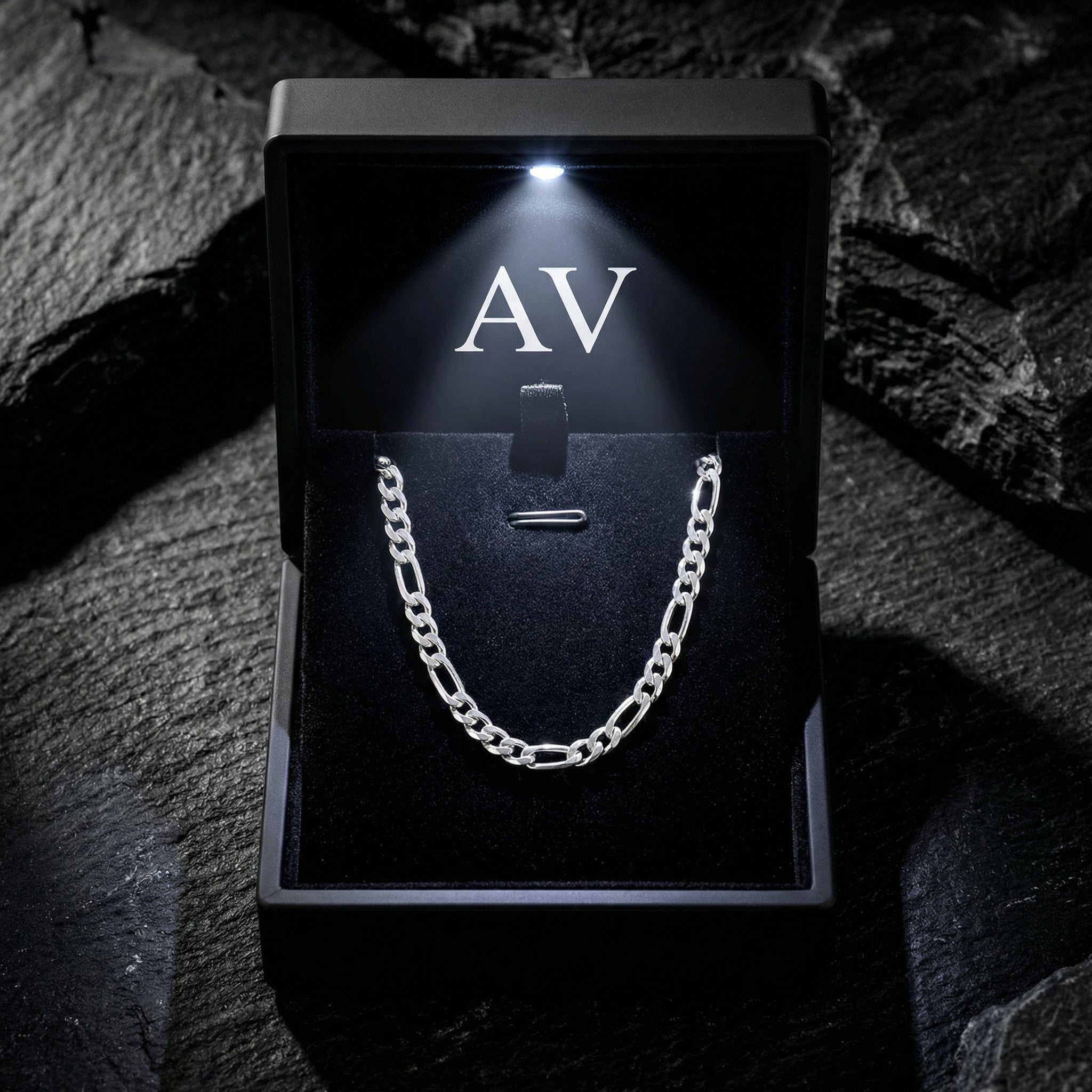 Silver stainless steel Figaro chain displayed in a premium black LED-lit jewelry box.