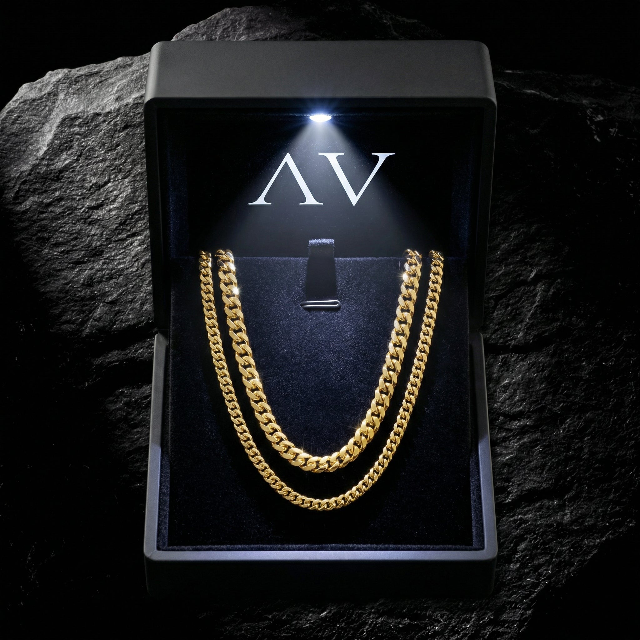 Two gold Cuban link necklaces presented in a black branded gift box with an LED light.