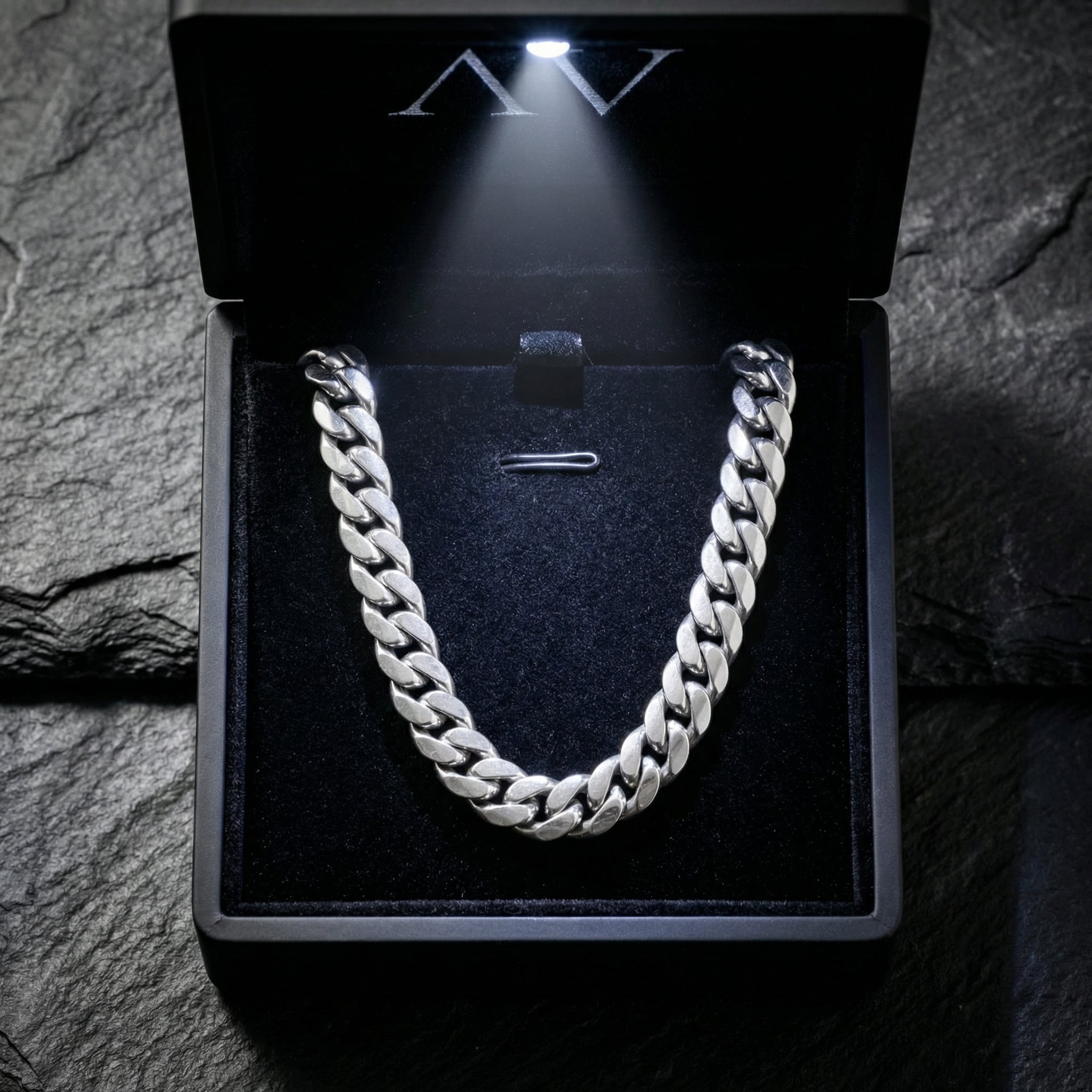 Silver stainless steel Cuban link chain inside a black LED-lit jewelry presentation box.