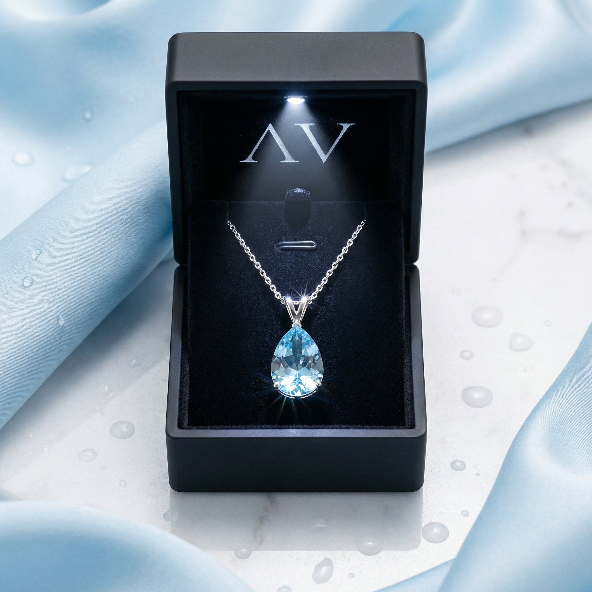 Sterling silver pear cut simulated aquamarine necklace inside a black lighted jewelry presentation box.